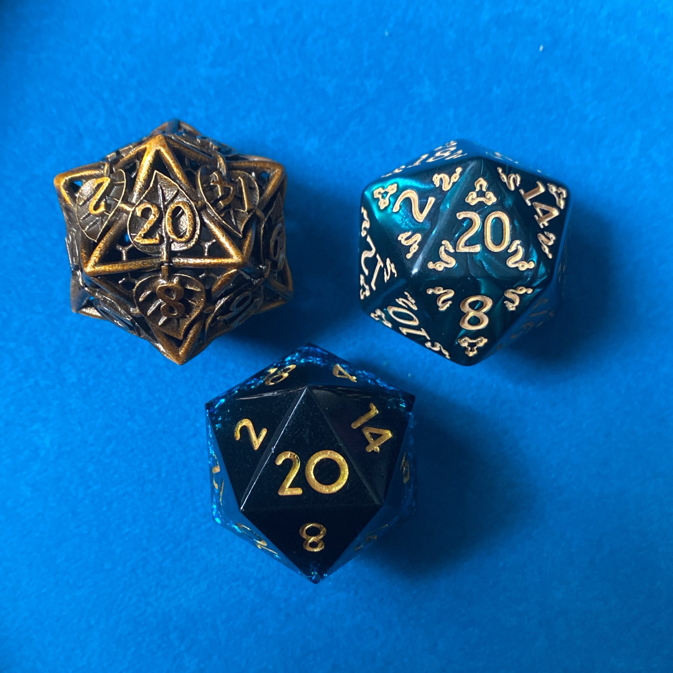 Two metallic dice, one with gold numbers and one with silver numbers, placed on a blue surface.