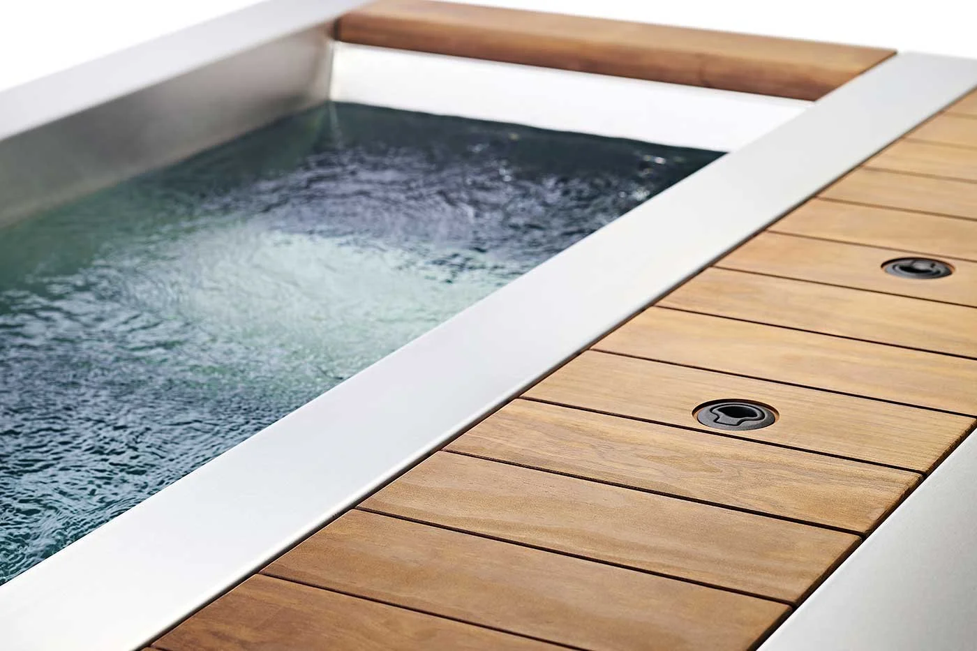 Close-up of a Tubmarine hot tub with water bubbling, surrounded by a stainless steel frame and wooden decking.