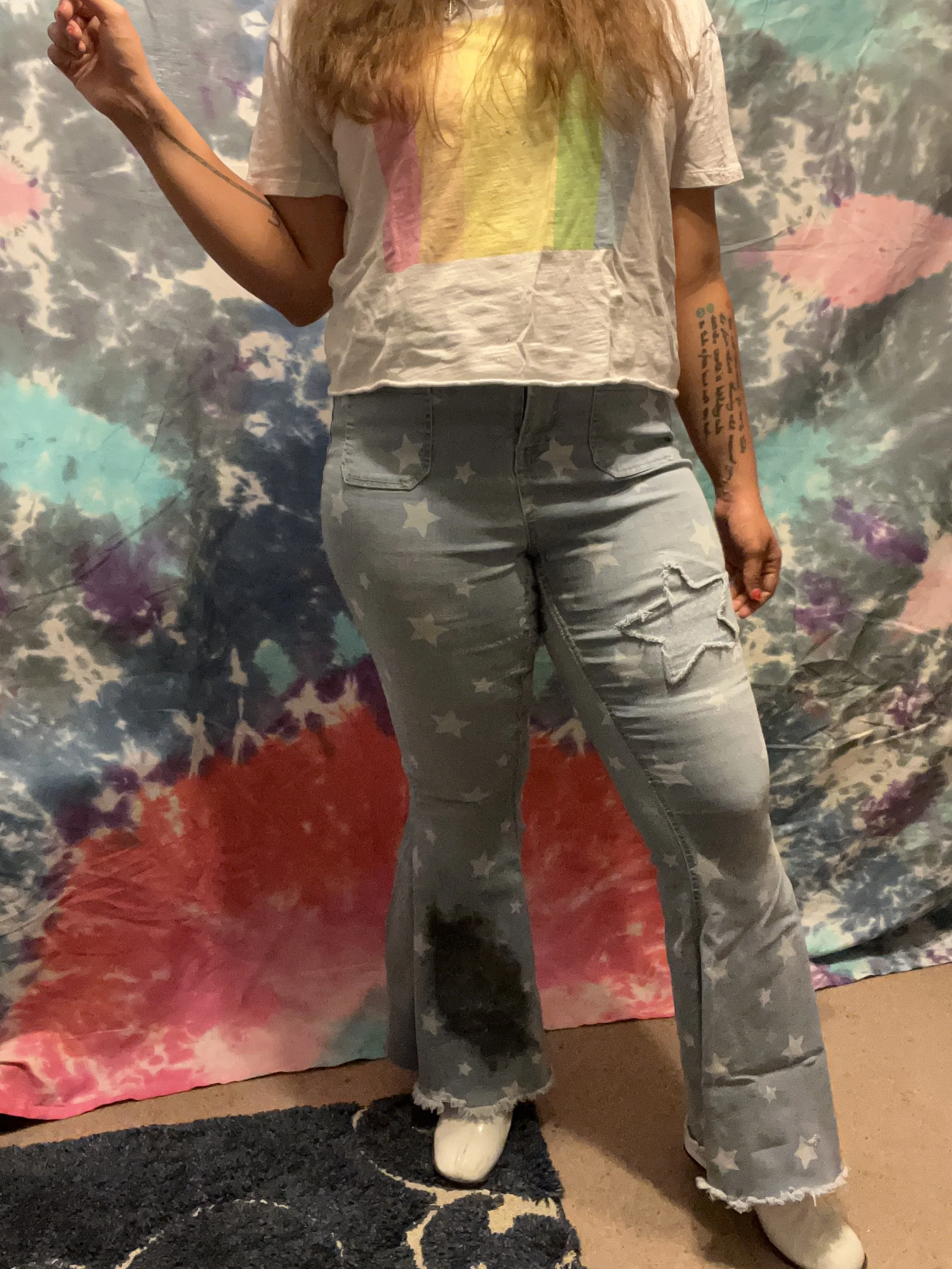 Star printed denim bell-bottoms with light wash denim flare detail, star reverse-applique detail on left upper leg and galaxy paint splotch on the right lower leg