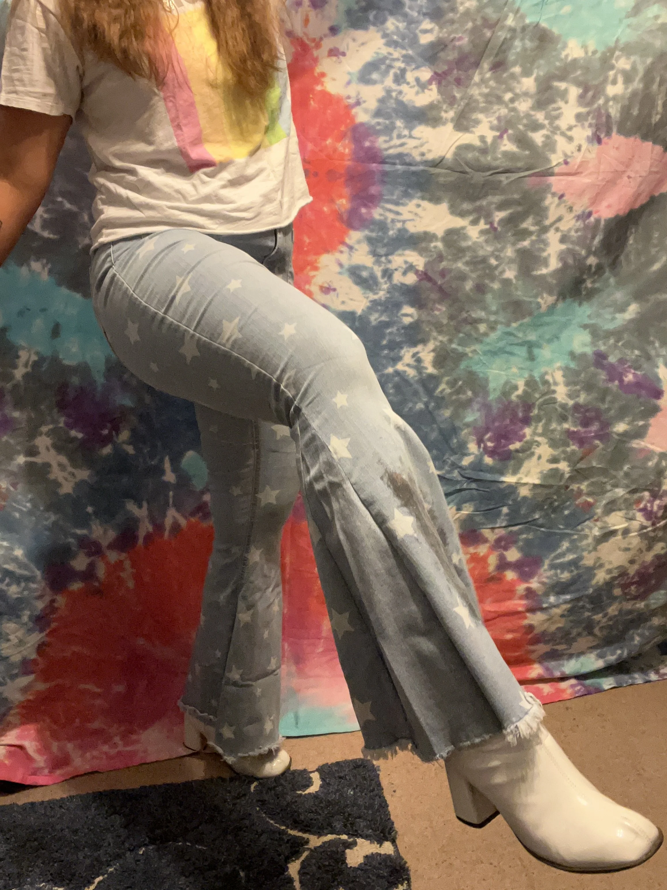 Star printed denim bell-bottoms with light wash denim flare detail, star reverse-applique detail on left upper leg and galaxy paint splotch on the right lower leg