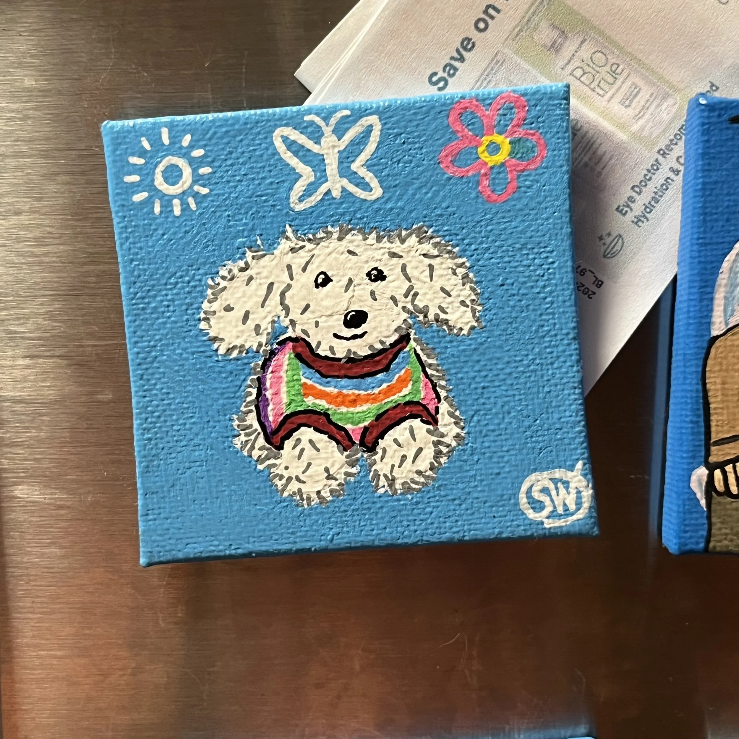 Cute stuffed animal dog in a rainbow sweater matching friendship magnet painting