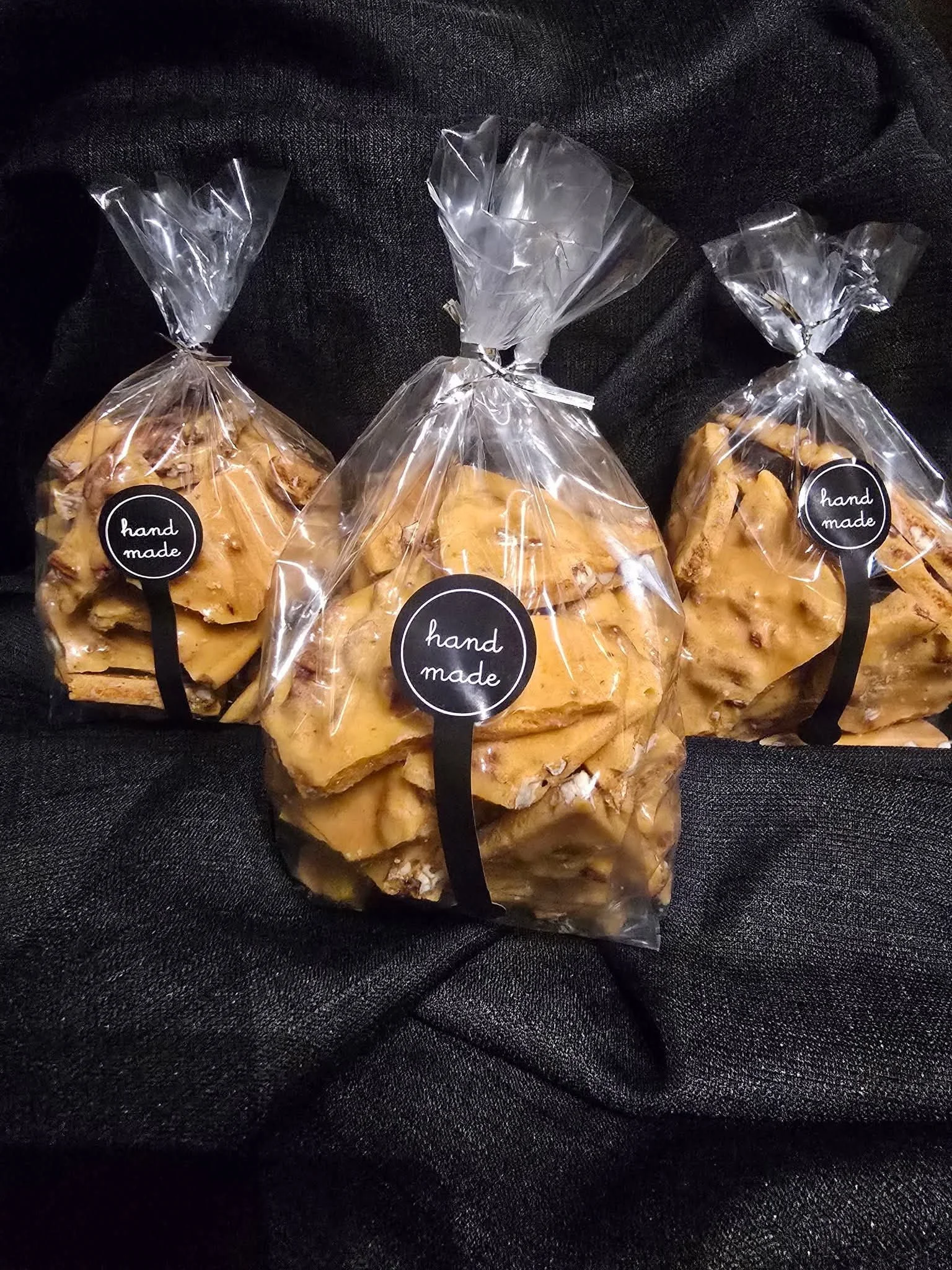 Packaging of pecan brittle candy on black fabric.