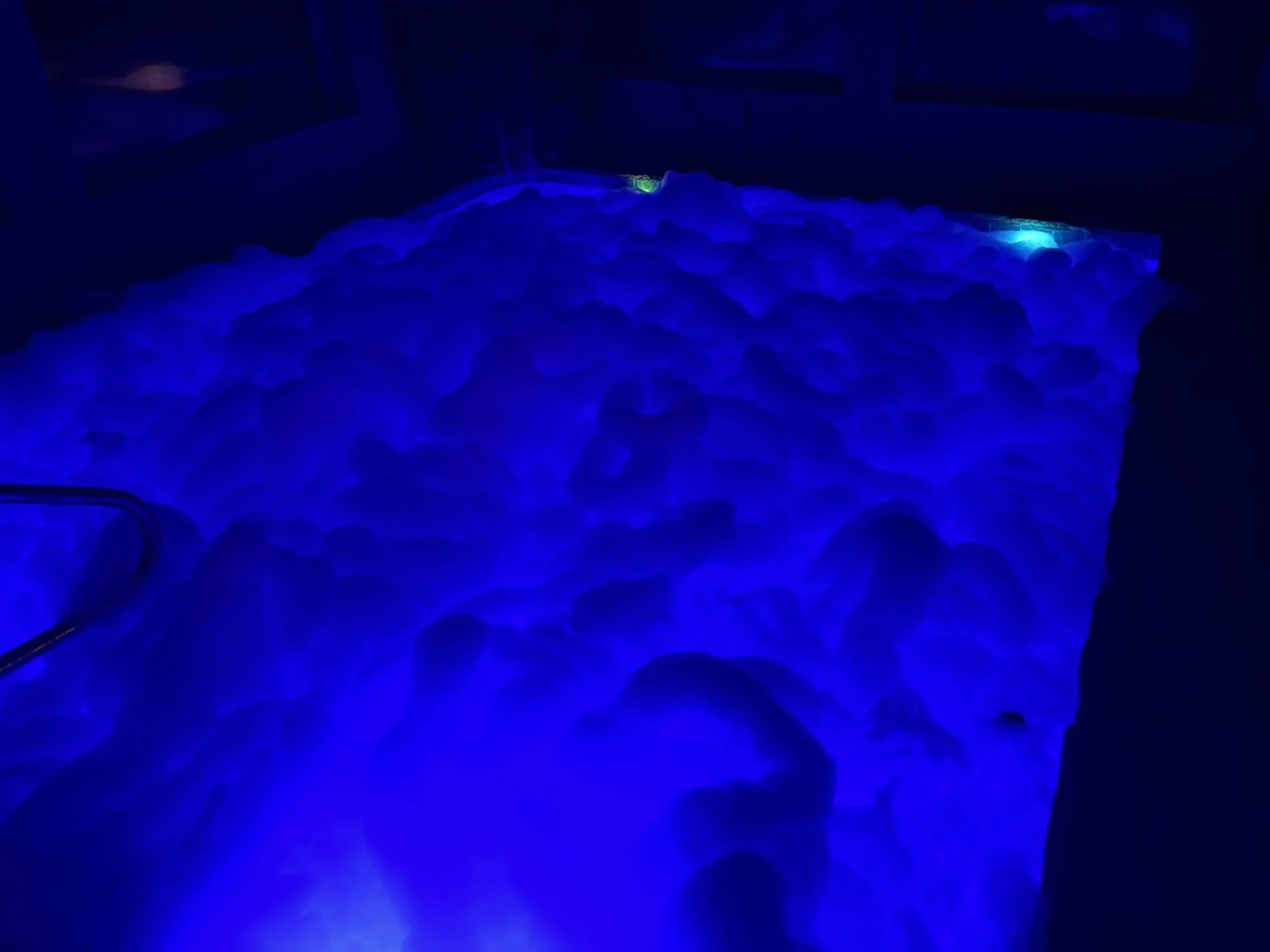 A surface with glowing blue lights and irregular bumps, illuminated by blue light in a dark environment.