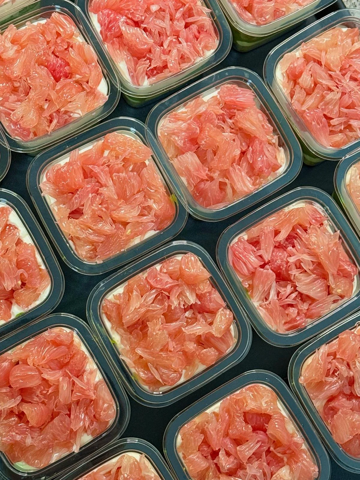 Multiple rectangular glass containers filled with a creamy layered dish topped with pickled ginger slices.