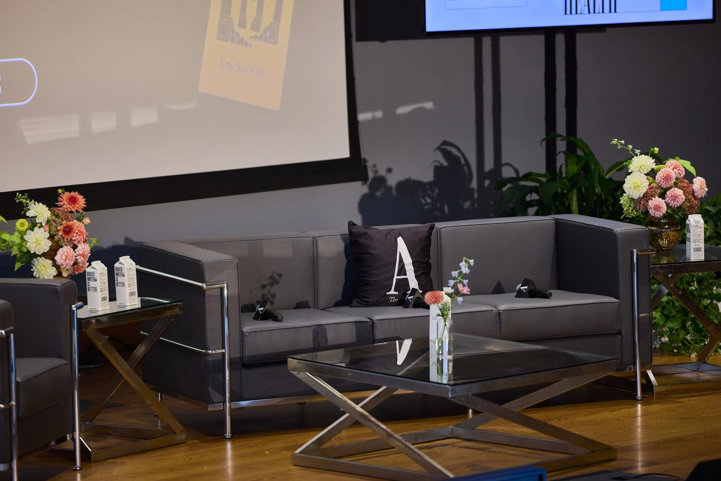 A stage set for a presentation hosted by The Atlantic at Washington University in St. Louis. Florals designed by St. Louis florist, Suncrest Blooms.