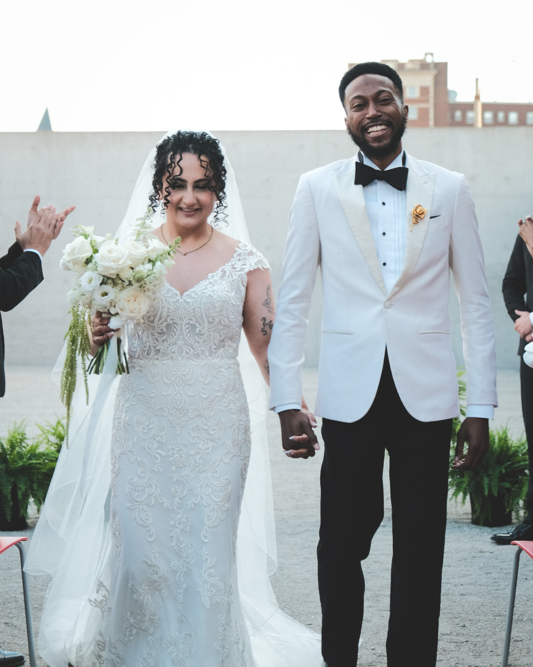 Happy couple walking down the aisle after getting married at St. Louis Contemporary Art Museum. Florals designed by St. Louis Florist, Suncrest Blooms.