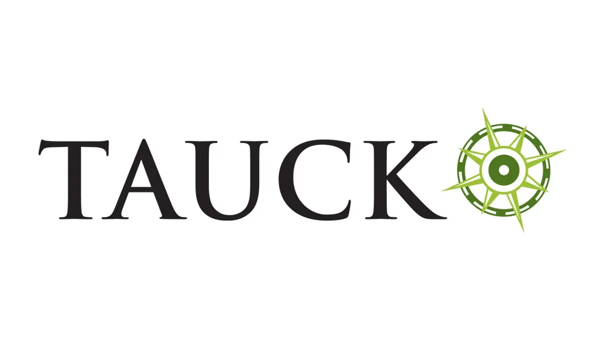 The word 'TAUCK' written in black, with a green compass rose graphic replacing the letter 'O'.