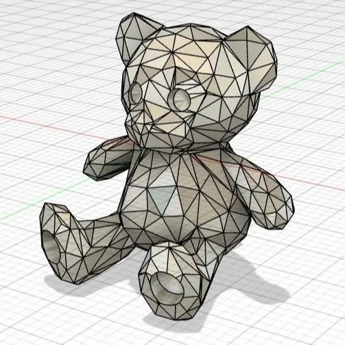 A 3D wireframe model of a teddy bear, created with connected geometric polygons, sitting on a grid surface.