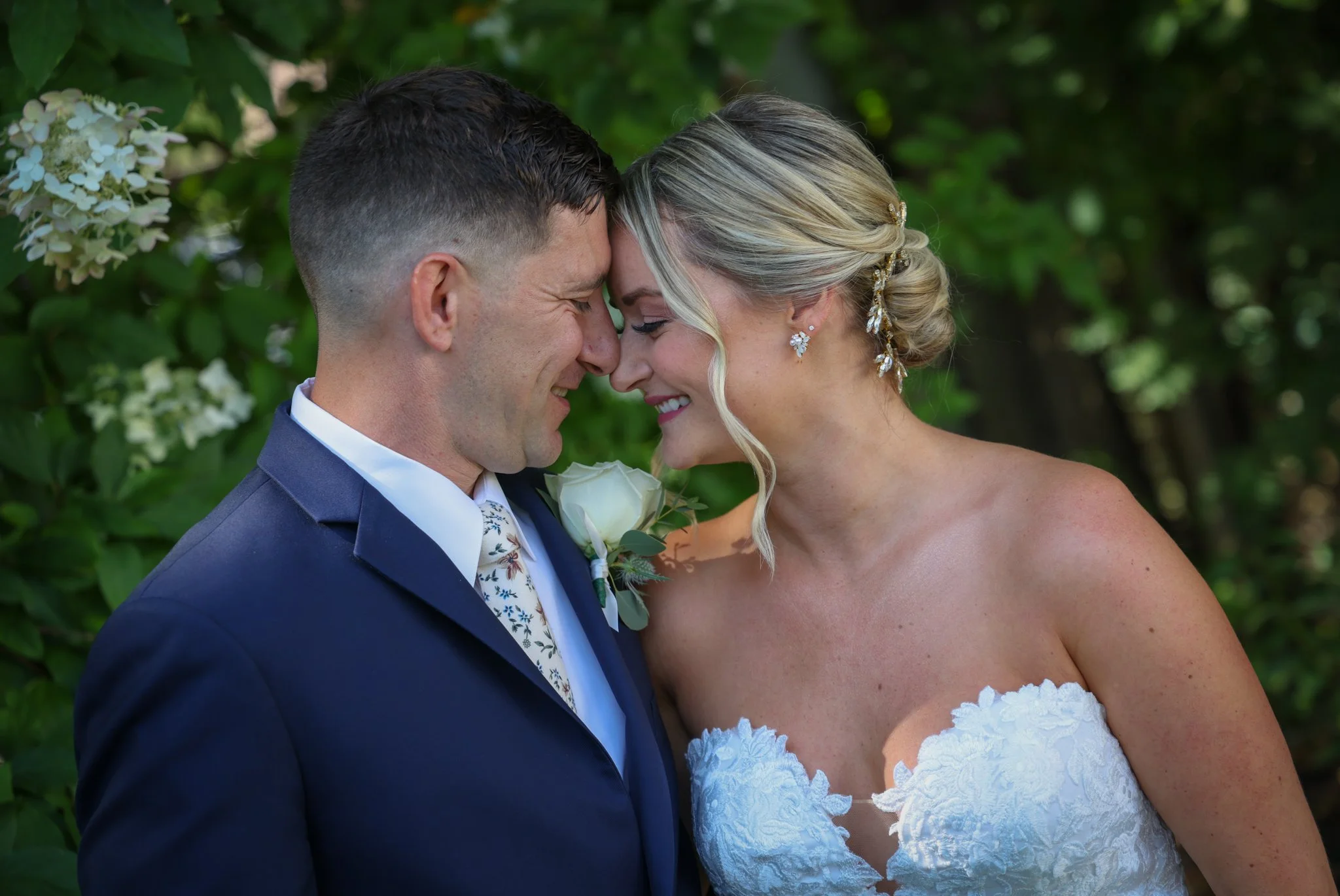 Newlyweds gently touching foreheads during an intimate New Hampshire mountain wedding, surrounded by natural scenery.