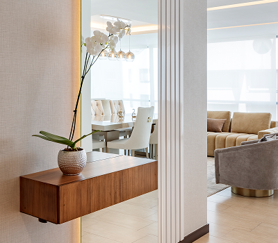 Modern living room and dining area with a potted orchid on a wooden side table