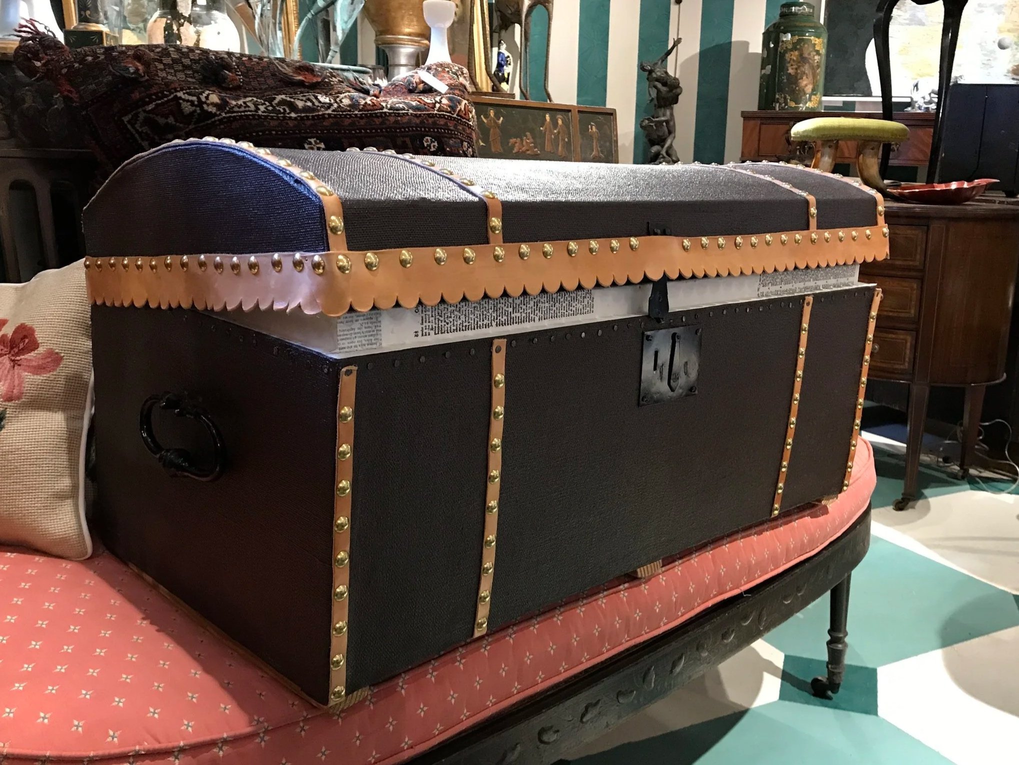 A travel trunk covered in painted canvas, trimmed for durability and beauty, yet affordable.