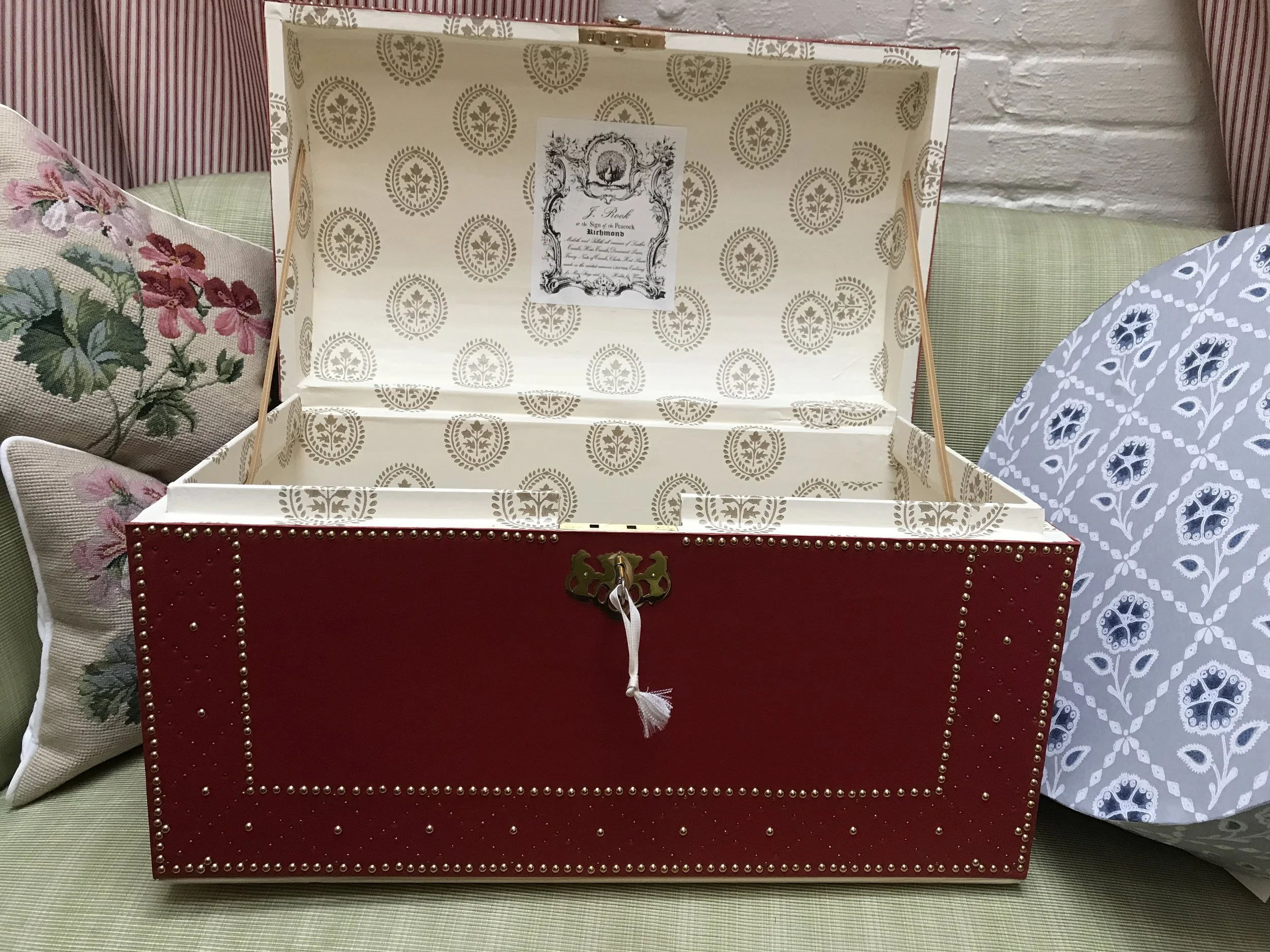 A late 18thc. wallpaper reproduction lines this chest.