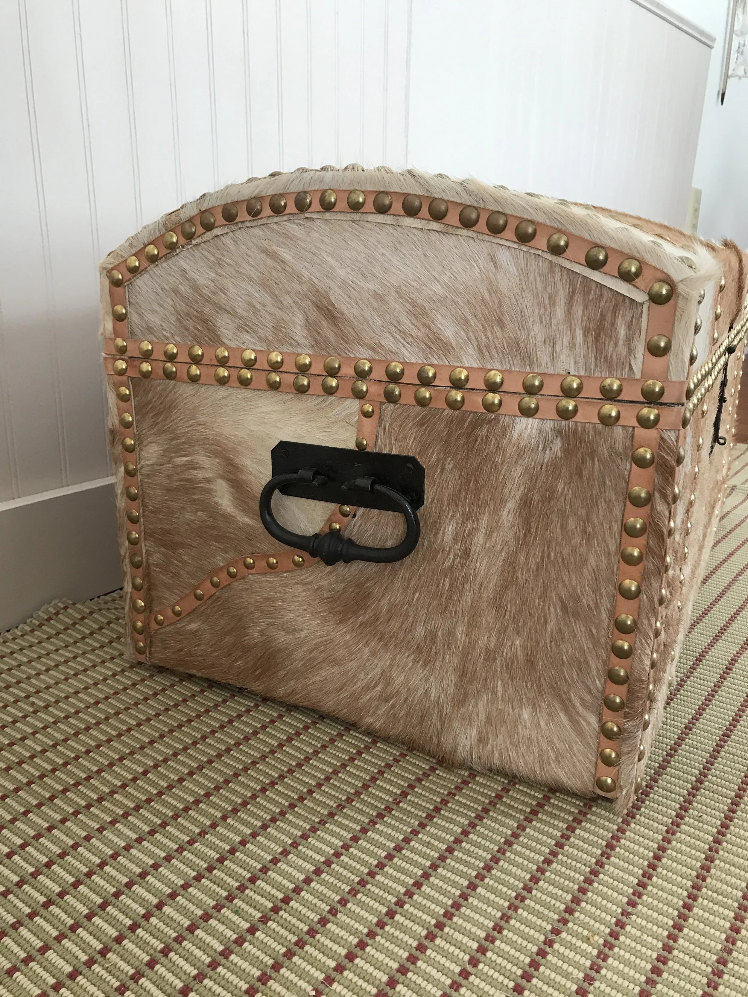 One side of the trunk has a pieced covering, the join hidden by a strip of leather and tacks. This is functional, keeping the hide from peeling up because of exposure to the elements.