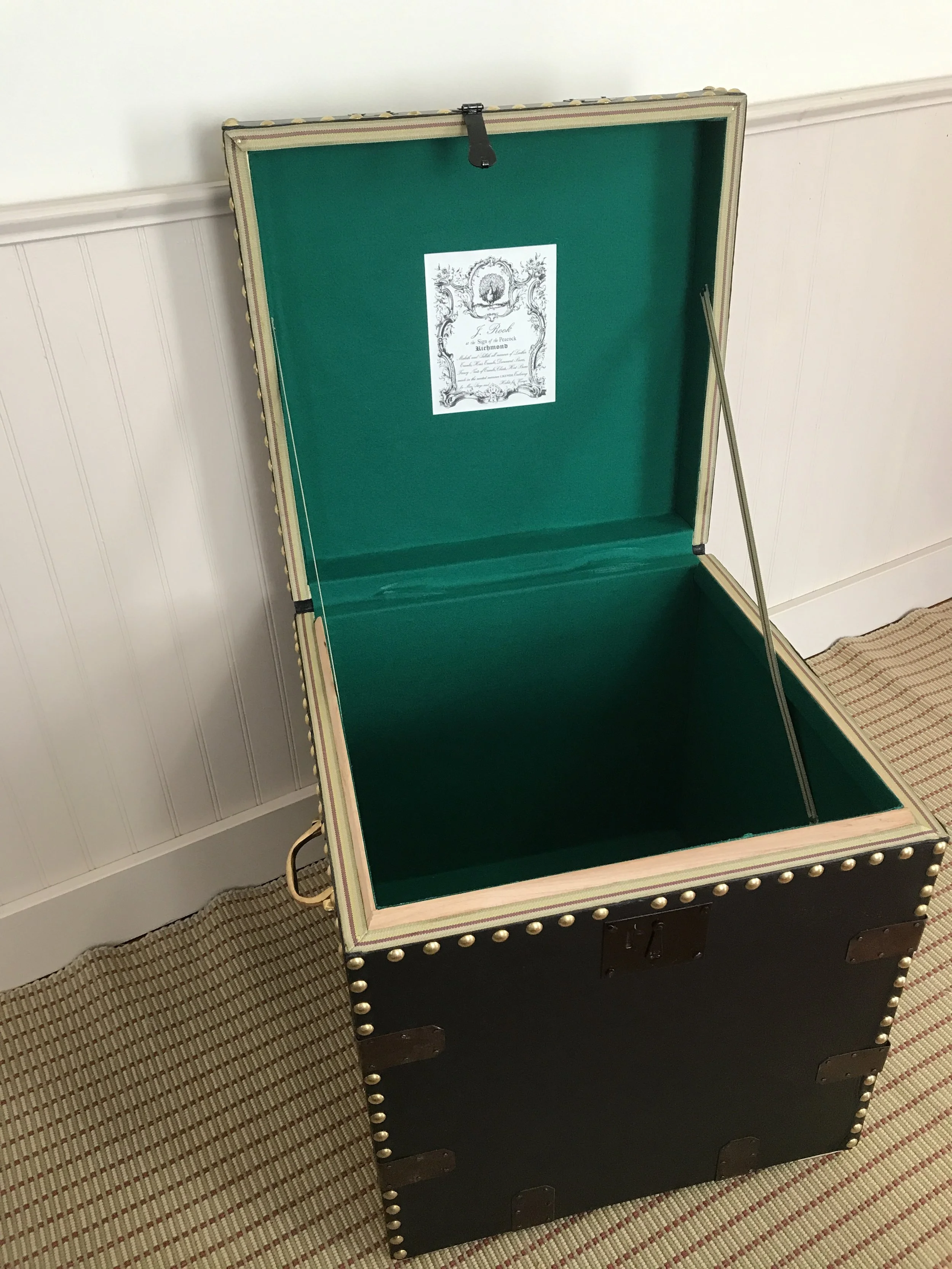 Interior lined with green "baize," a fulled wool fabric. Note that the interior valances are not covered, because of the thickness of the fabric. The opening edges are instead protected with ribbon.
