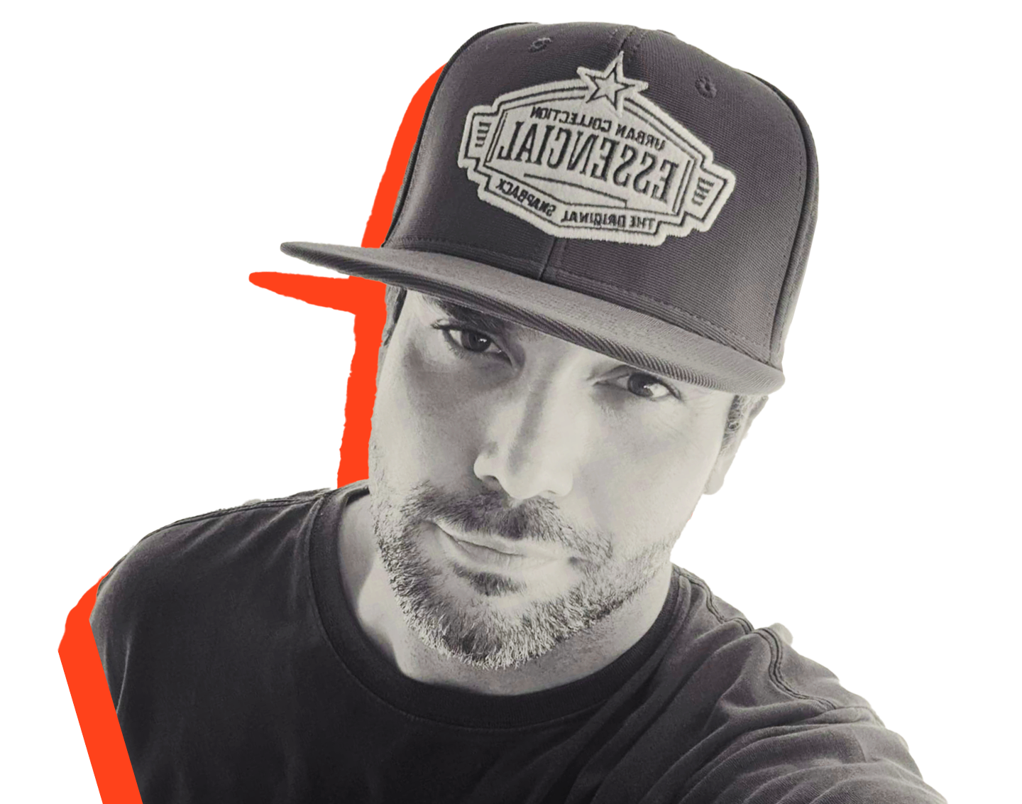 Black and white photo of a handsome man, wearing a cap. The cap is tilted, and the man has a slight smile and a beard.