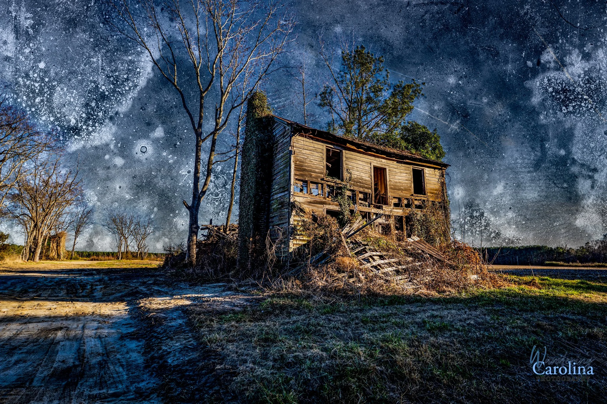 An abandoned, dilapidated wooden house with broken windows and stairs, surrounded by leafless trees under a starry night sky.
