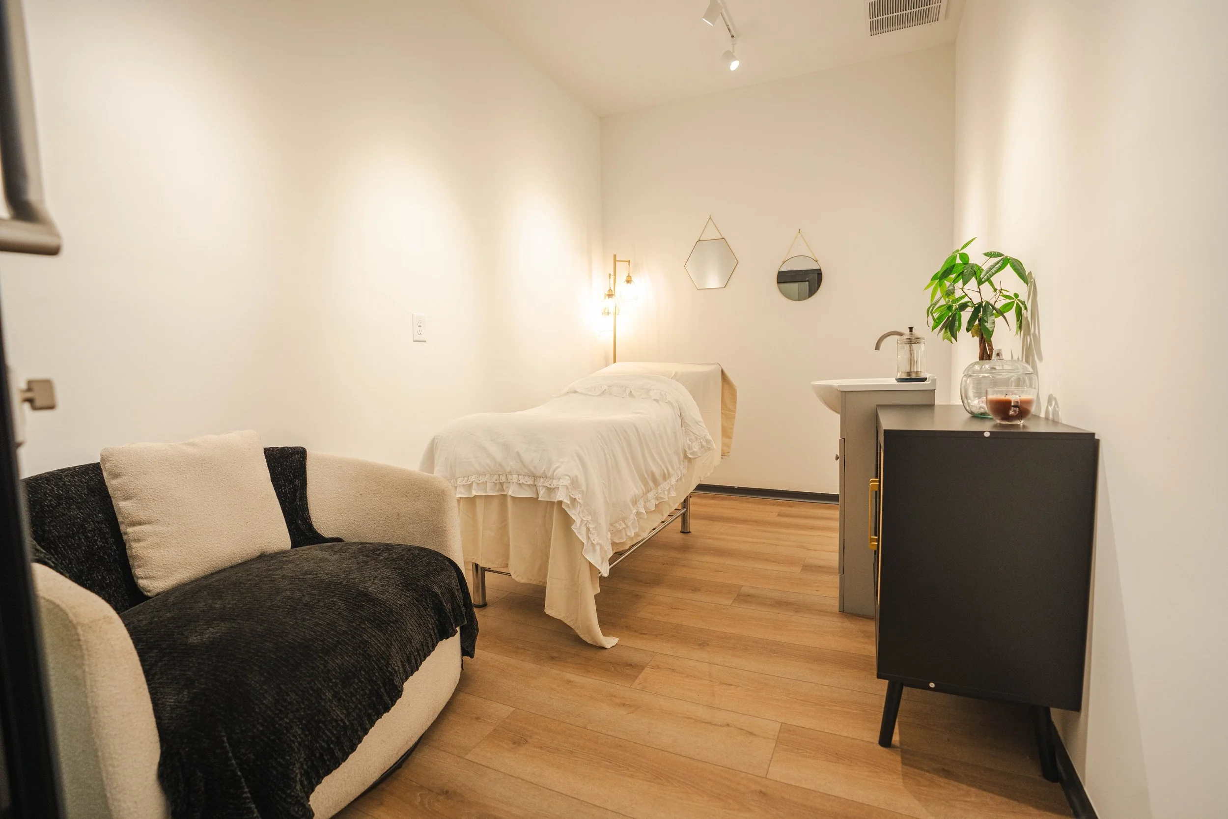 Interior of a hair salon with two oval mirrors, black hairdryers on a wooden shelf, and a neon sign on the wall that says "You're like really pretty" in cursive script.