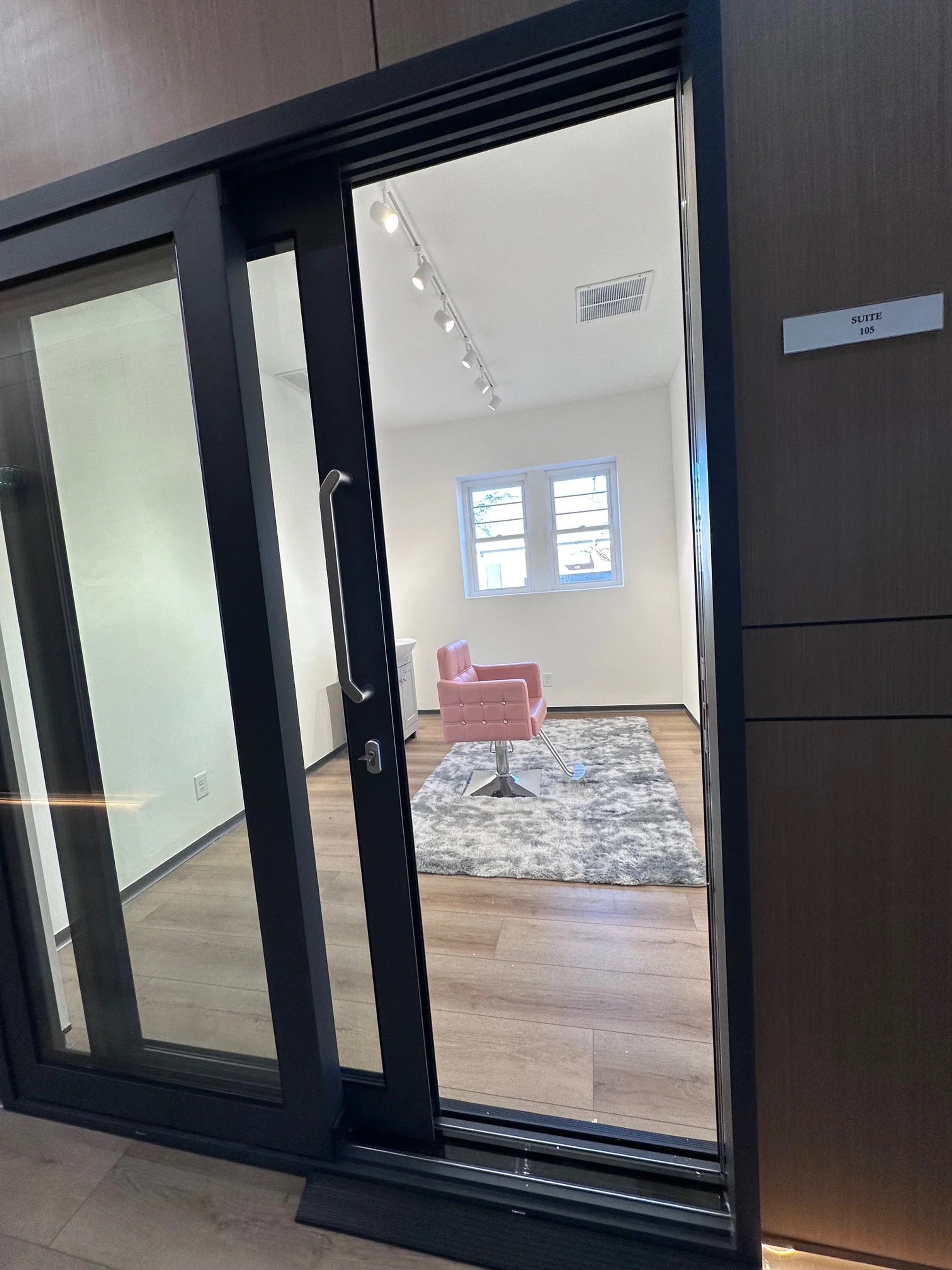 Salon with two mirrors, black hair dryers, and a neon sign that reads "You're like really pretty" on the wall.
