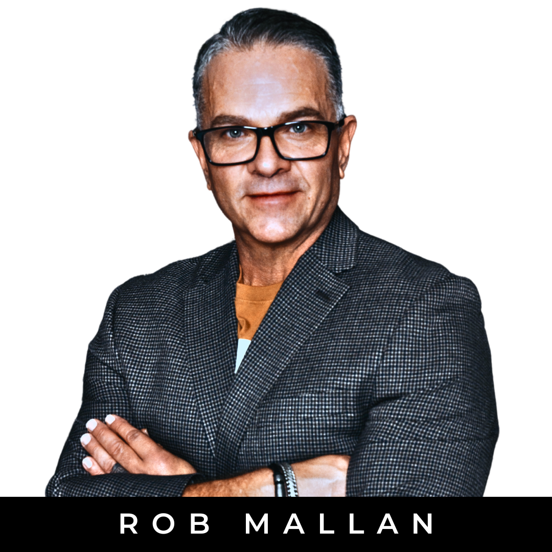 A middle-aged man with gray hair, wearing glasses, a dark checkered blazer, and a yellow shirt, standing with arms crossed against a white background with a black band at the bottom displaying the text 'Rob Mallan'.