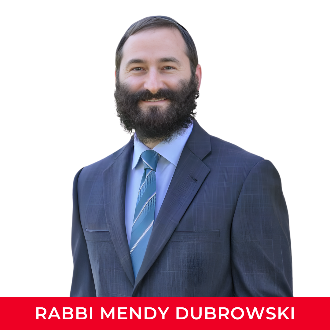 A man wearing a dark blue suit, light blue shirt, and striped blue tie, smiling with a beard and short dark hair.