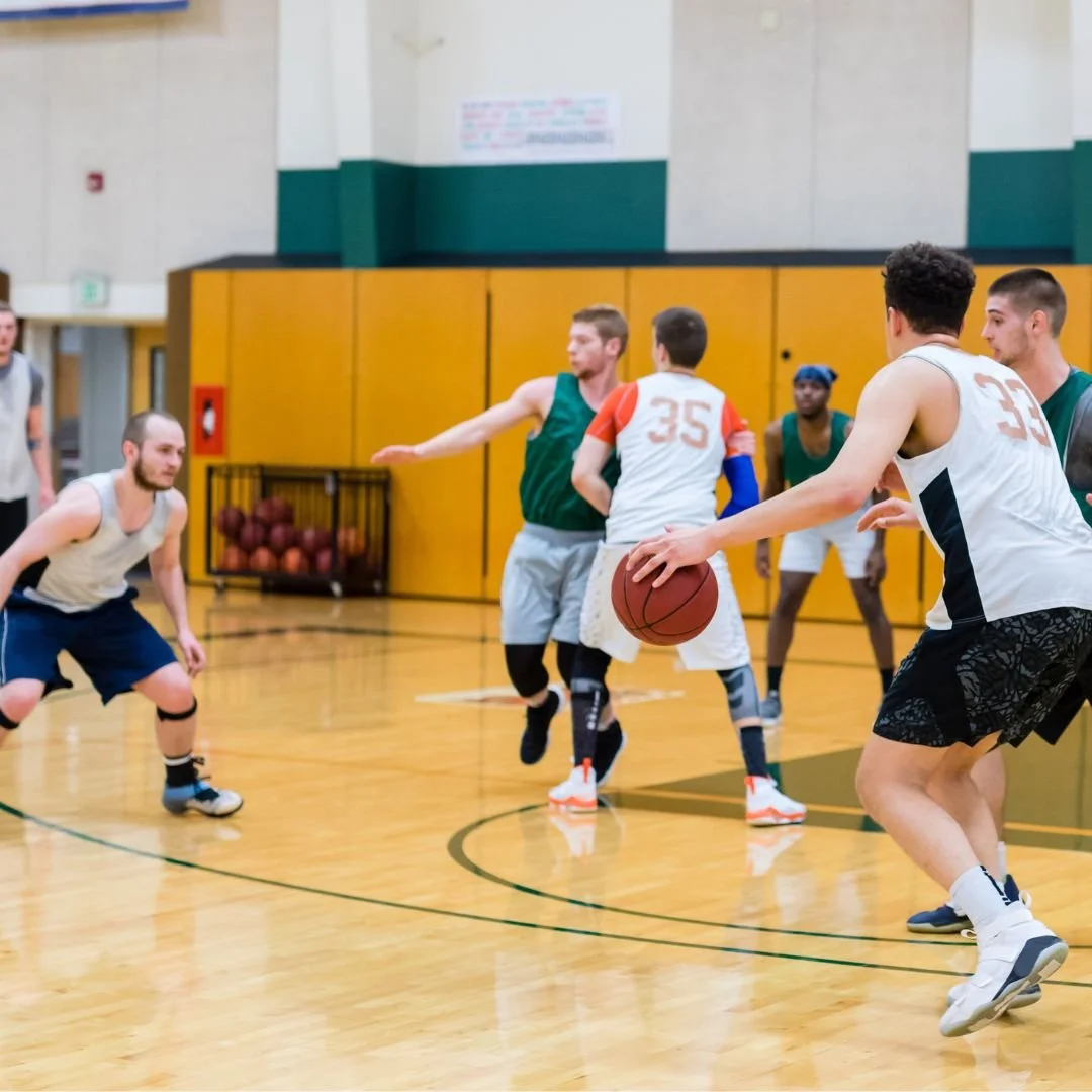 Basketball team taking a photo in the bleachers holding a trophy