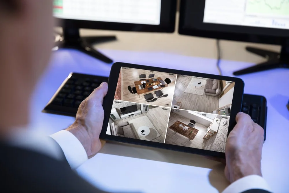 Close-up Of A Businessman Looking At CCTV Security Camera Footage On Digital Tablet