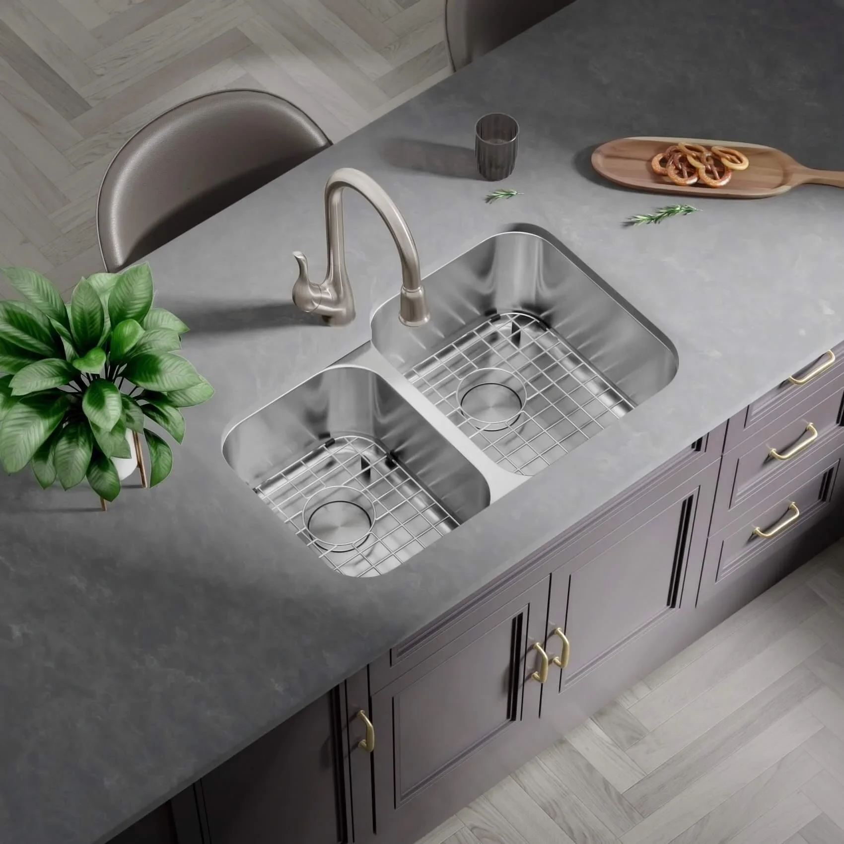 A kitchen sink with a plant to the left, a glass and a wooden tray with a pretzel on the countertop, and a chair in the background.