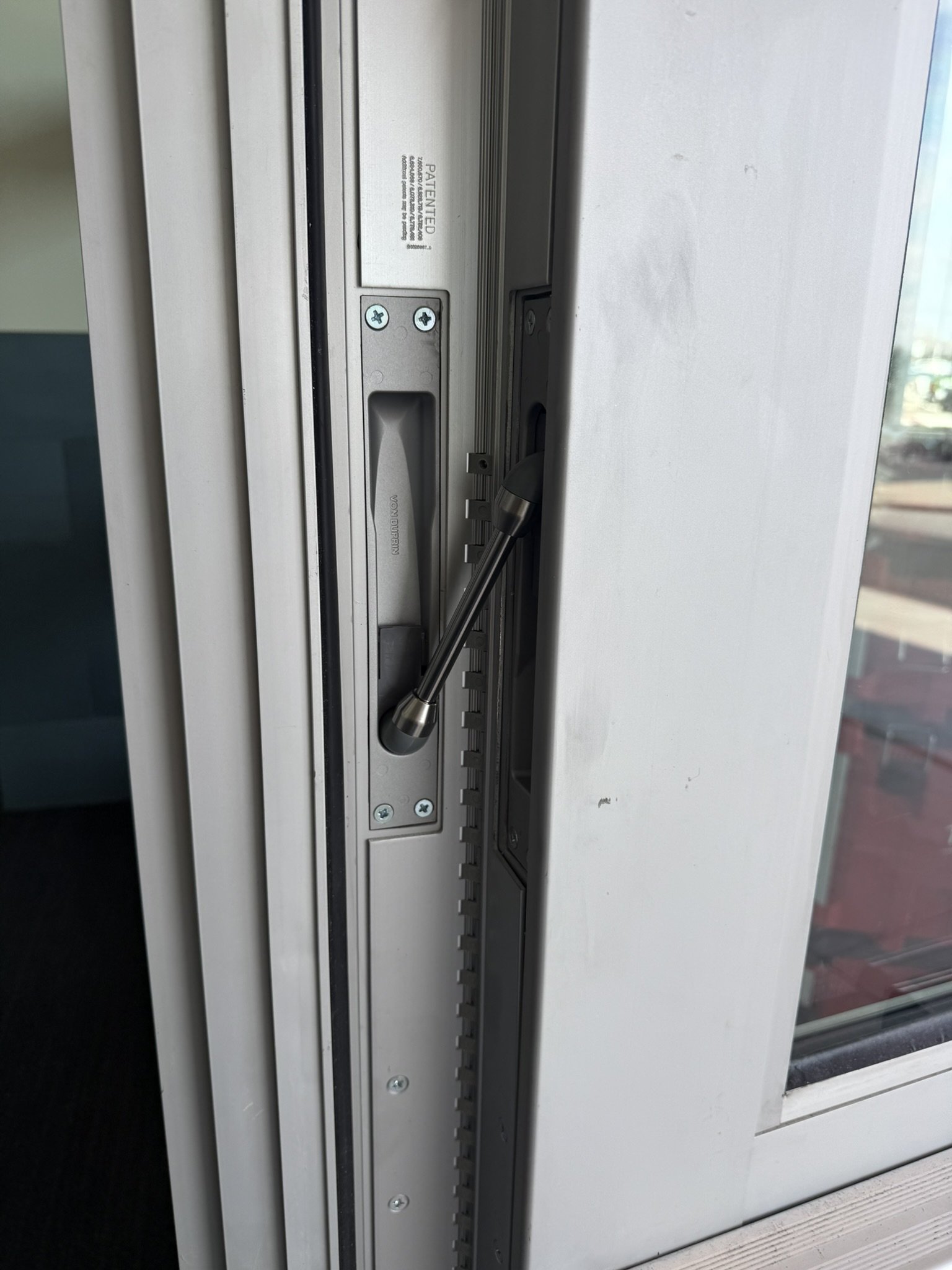 Close-up of a sliding glass door lock mechanism with a handle and locking track.