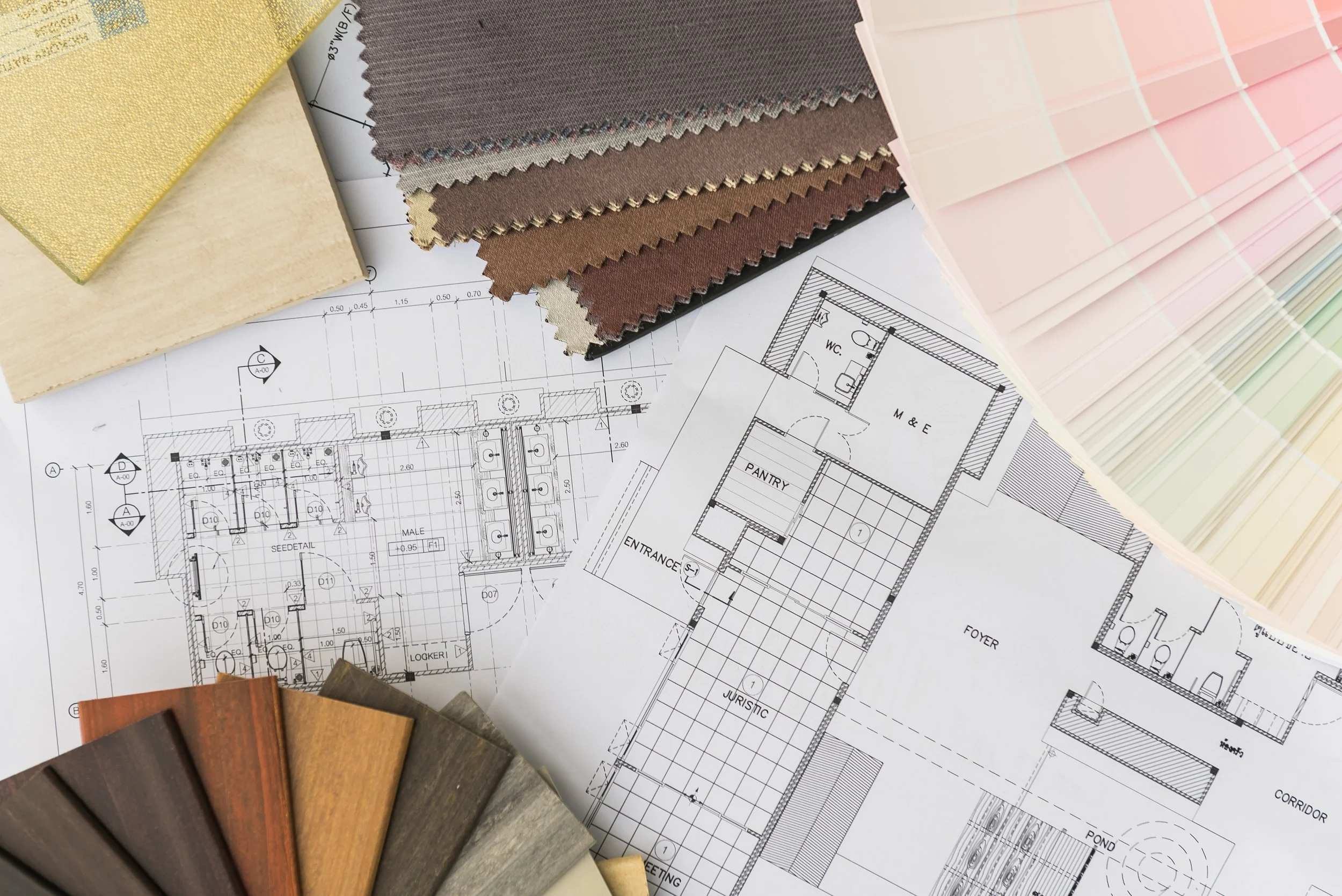 A small home office with a desk, chair, computer, and a living area with a sofa and coffee table.