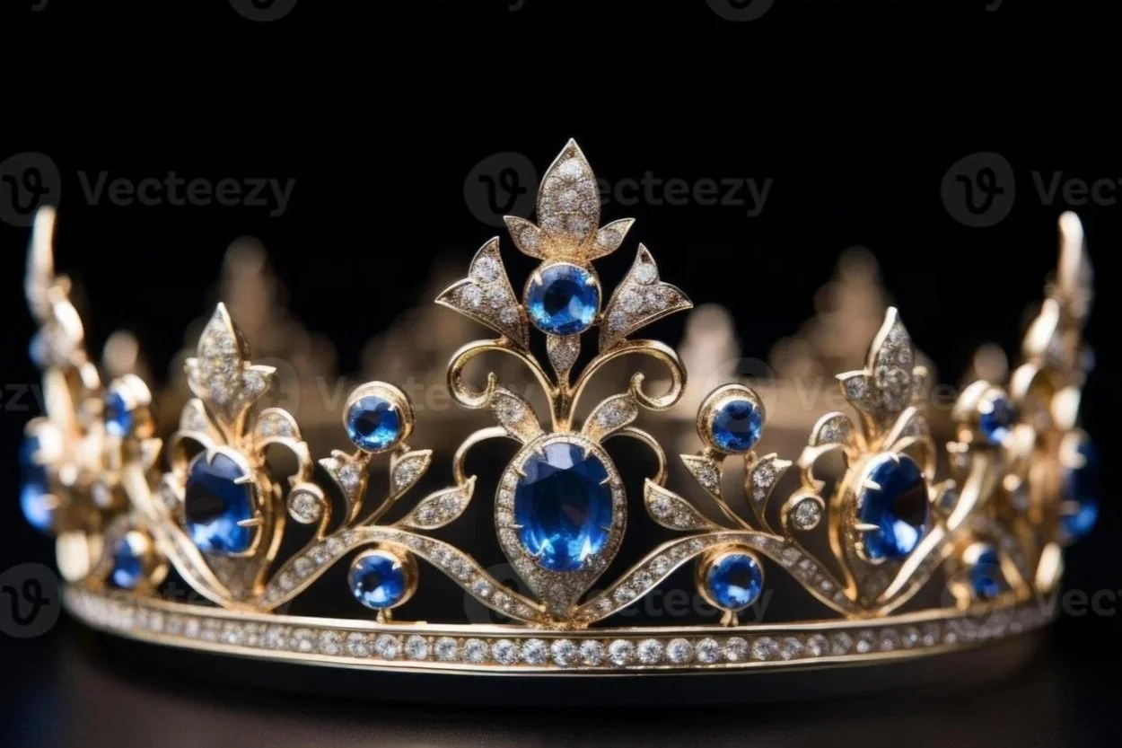 A gold tiara adorned with blue gemstones and small diamonds, designed with floral and scroll motifs.