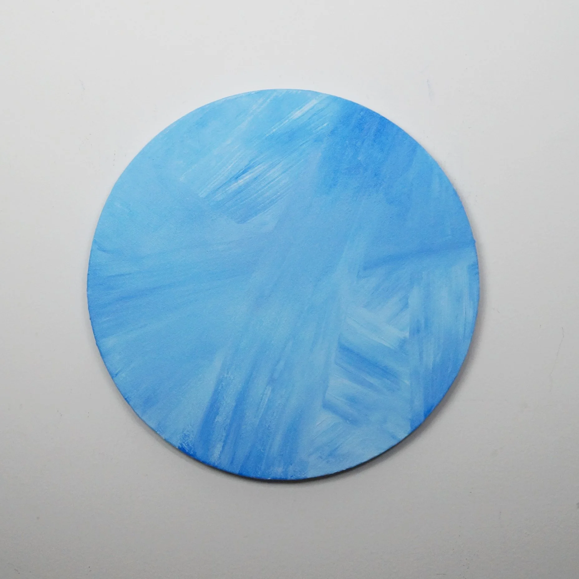 bright blue painting on circular canvas by Nicole Javorsky