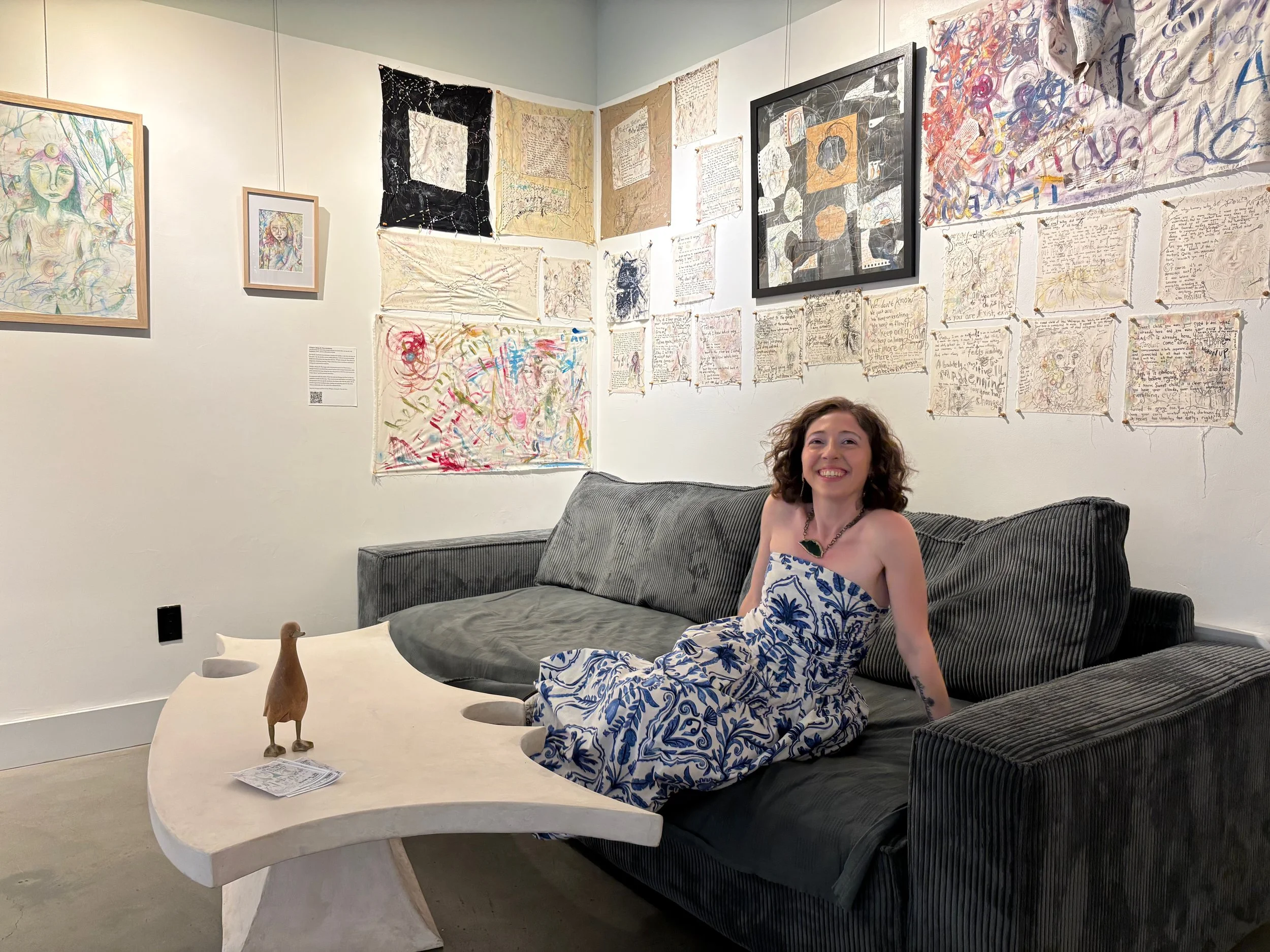 artist-nicole-javorsky-on-couch-with-her-tapestry-art-installation.jpeg
