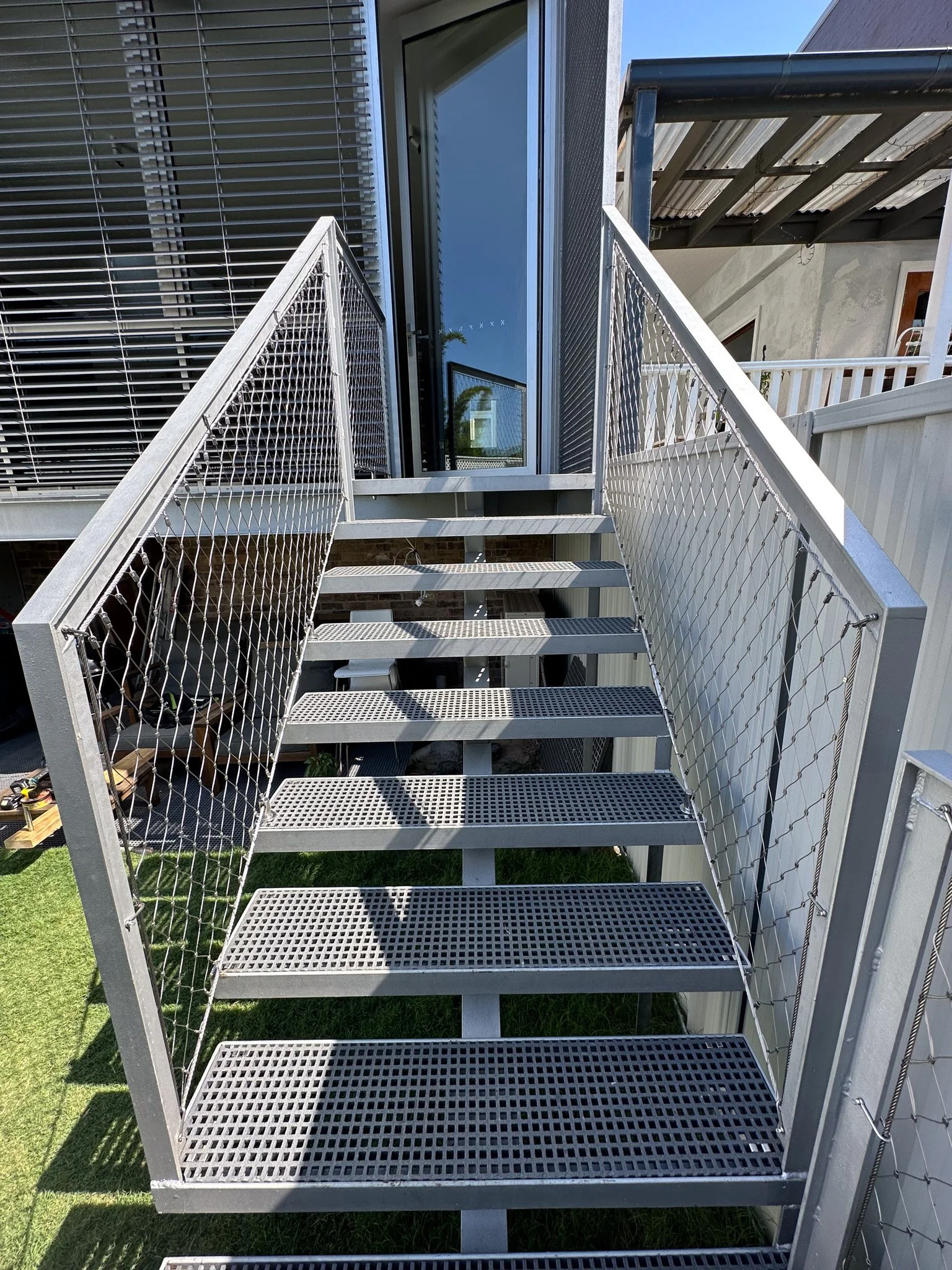 Flexi-mesh balustrades installed by Bespoke Wire & Rope in Stanmore NSW with realBUILDING, including balcony and staircase infills.