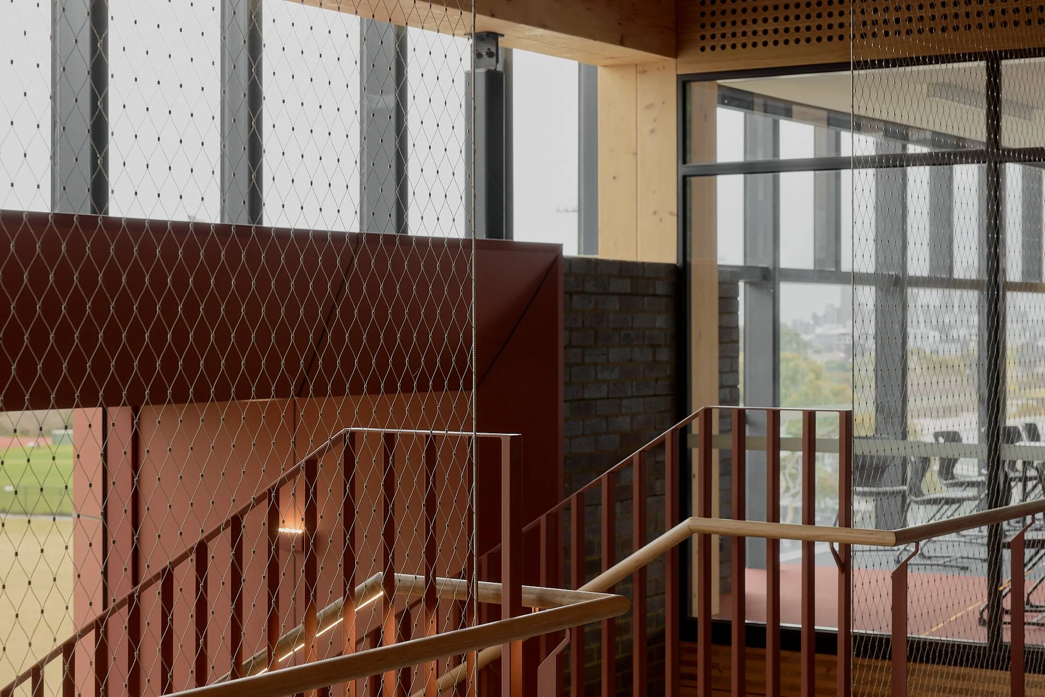 Floor-to-ceiling Flexi-mesh balustrades installed by Bespoke Wire & Rope at Xavier College Kostka Building in Kew VIC with Ireland Brown Construction, MGS Architects, and Forged Steelworks.