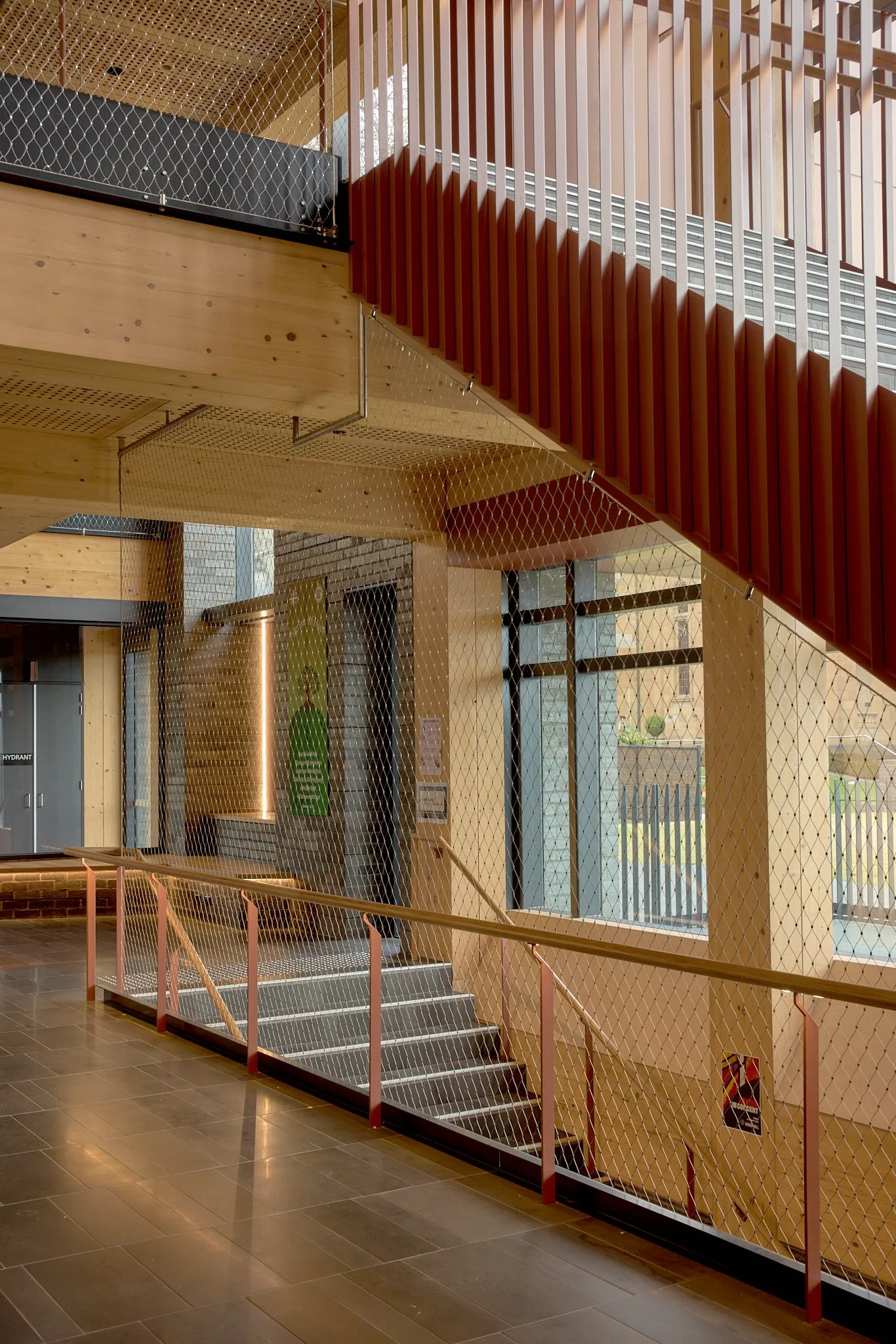 Floor-to-ceiling Flexi-mesh balustrades installed by Bespoke Wire & Rope at Xavier College Kostka Building in Kew VIC with Ireland Brown Construction, MGS Architects, and Forged Steelworks.