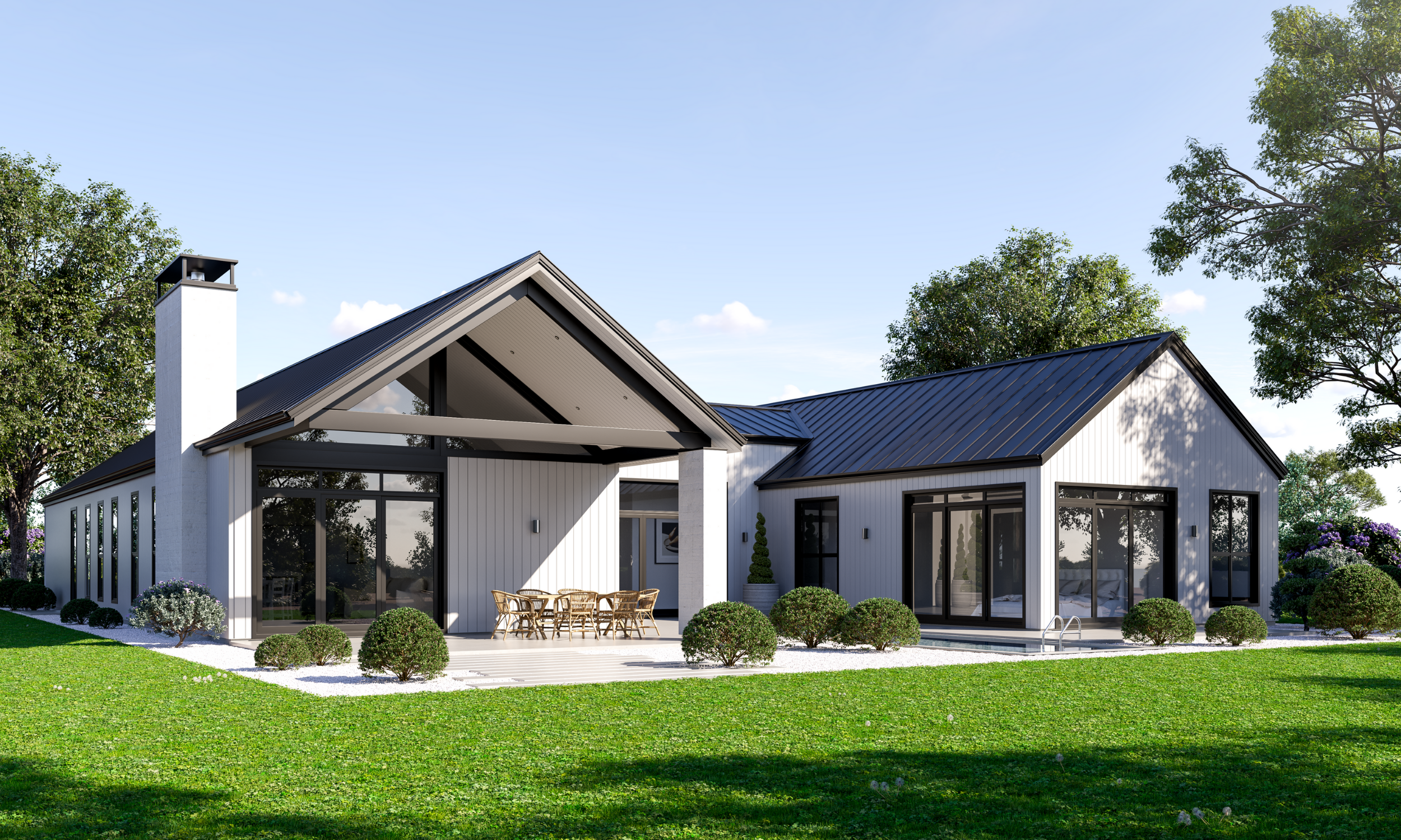 Modern white house with black trim, metal roof, and large glass windows, surrounded by green lawn and trees.