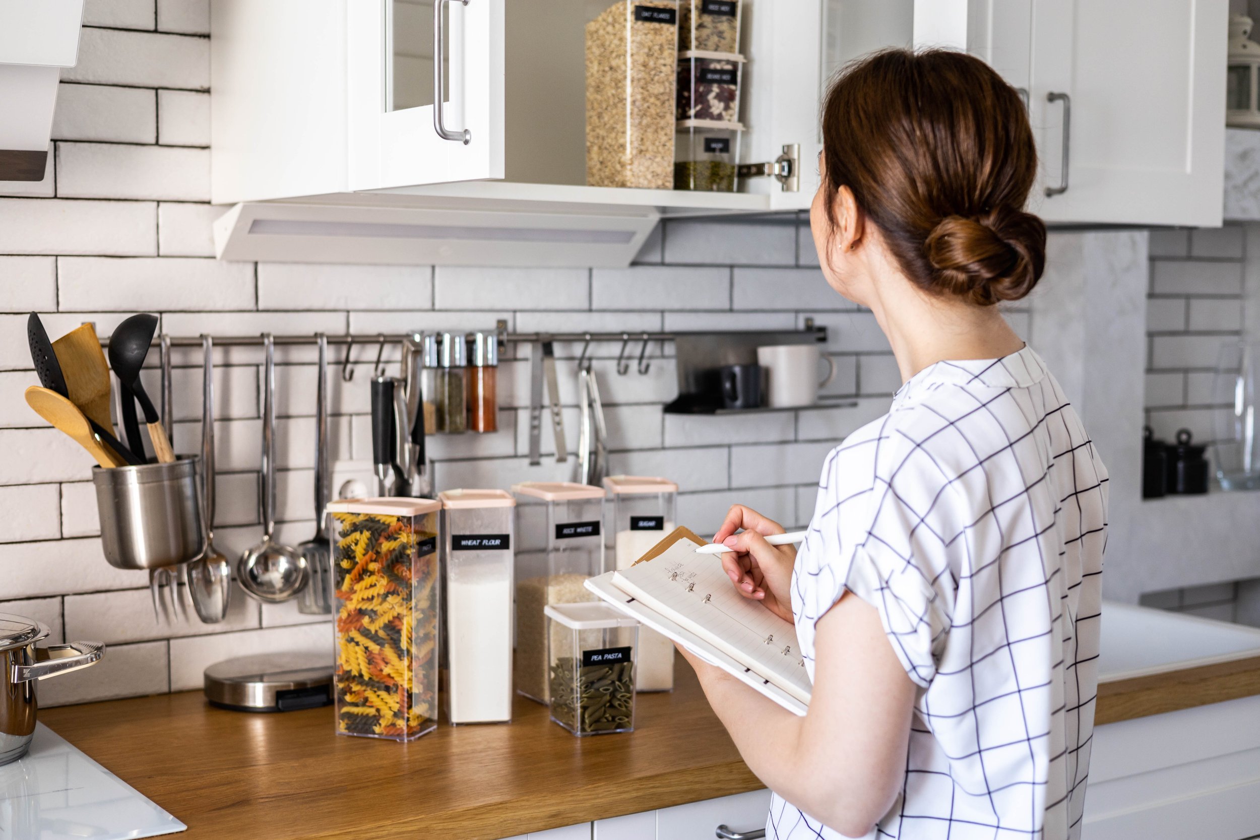 Professional home organiser working in a beautifully organised kitchen.