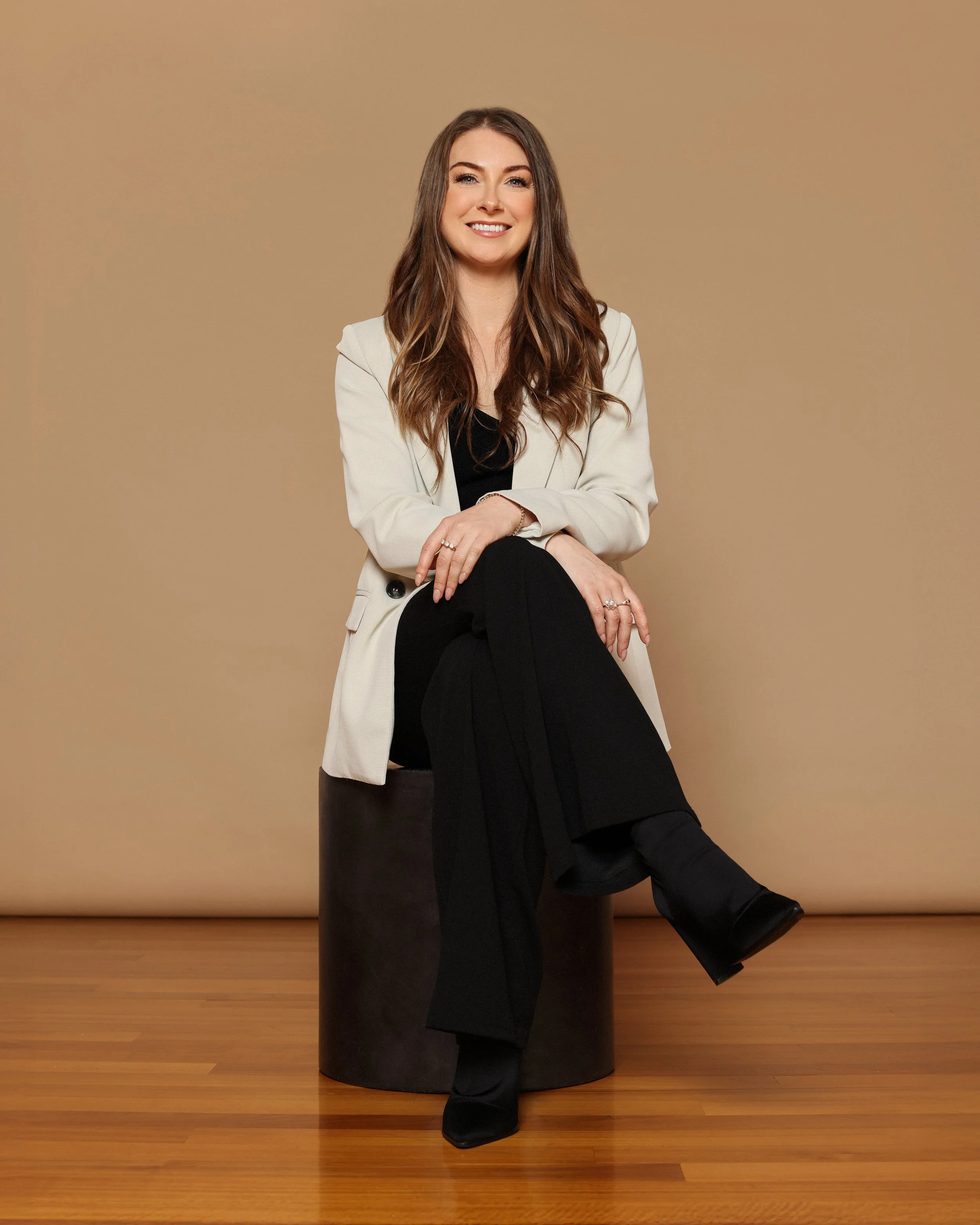 Professional organiser from Spaces by Kat, photographed in a clean, modern studio setting, reflecting the calm, approachable style of the business.