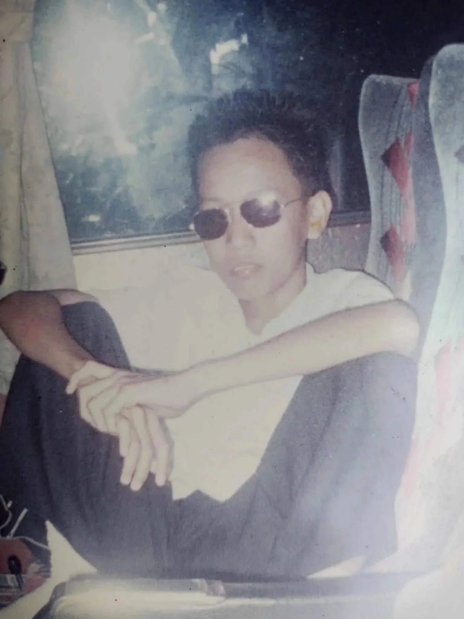 A photo of young Allan Mandi sitting on a bus.