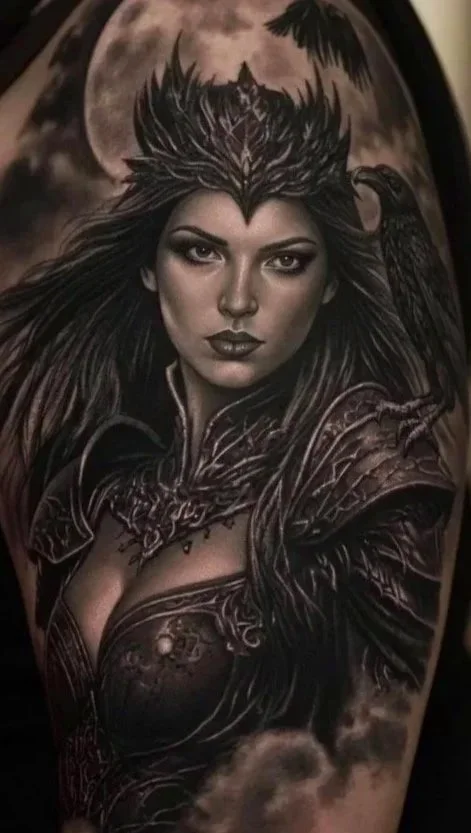 Black and gray tattoo of a fierce woman with a wolf headdress, a raven perched on her shoulder, dark clouds, and a large moon in the background. Valkyrie-theme Tattoo done by Allan Mandi realism tattoo Artist from Knoxville Tennessee