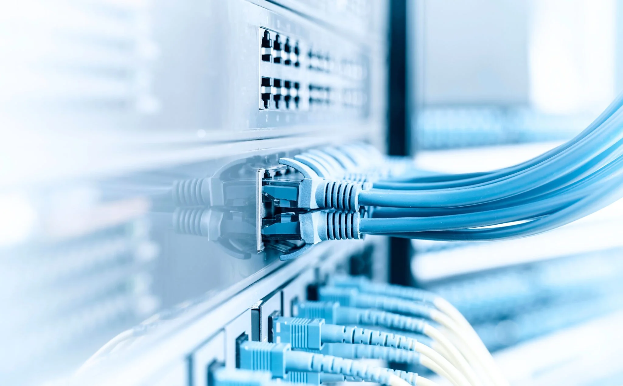 Close-up of network switches and Ethernet cables plugged in, in a data center or networking environment.