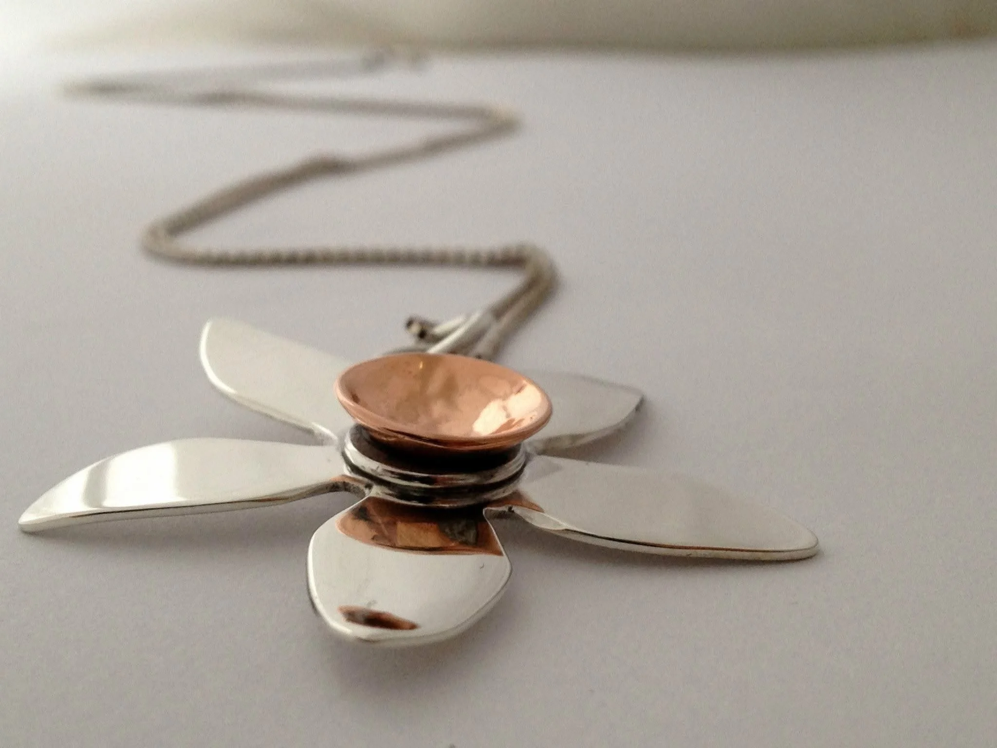 Stacked spoons and forks on a flat surface.