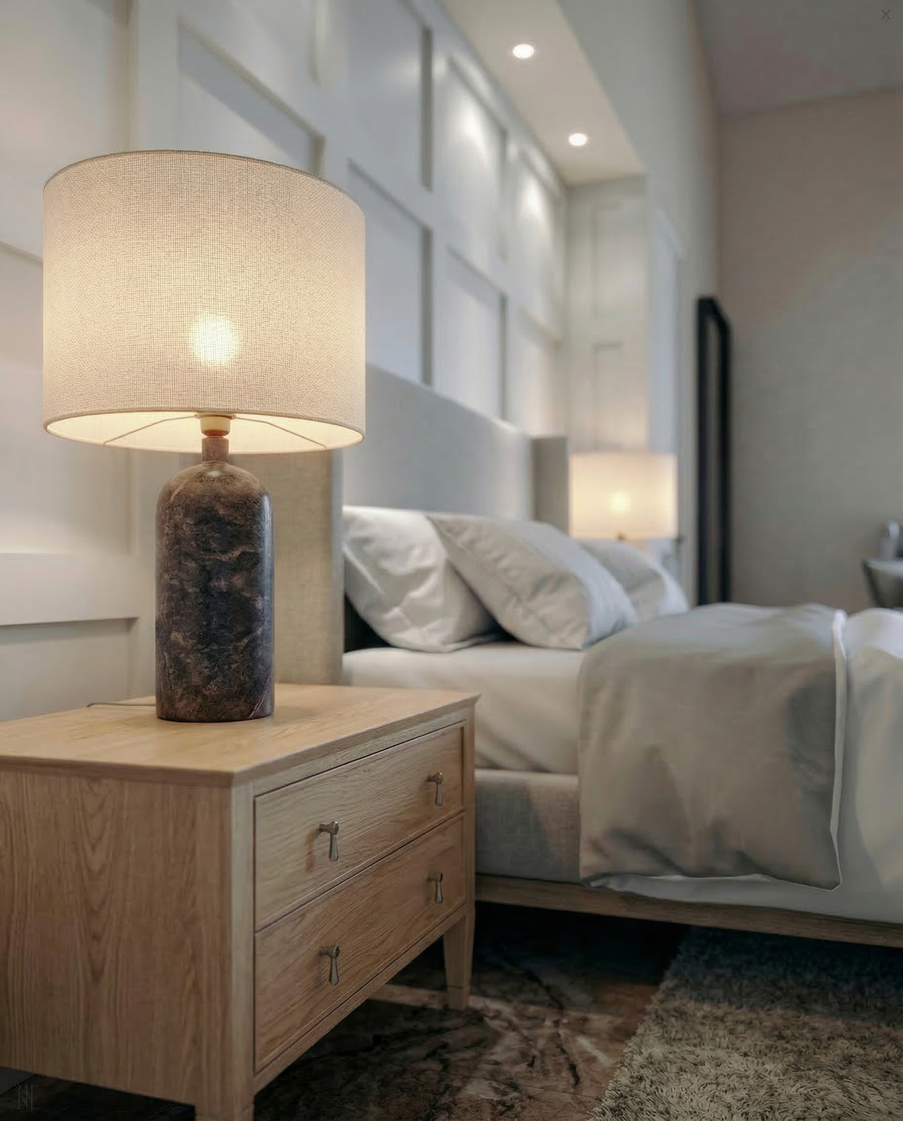  bedside table with a lamp and a bed with white pillows and bedding in a cozy bedroom with wall paneling.