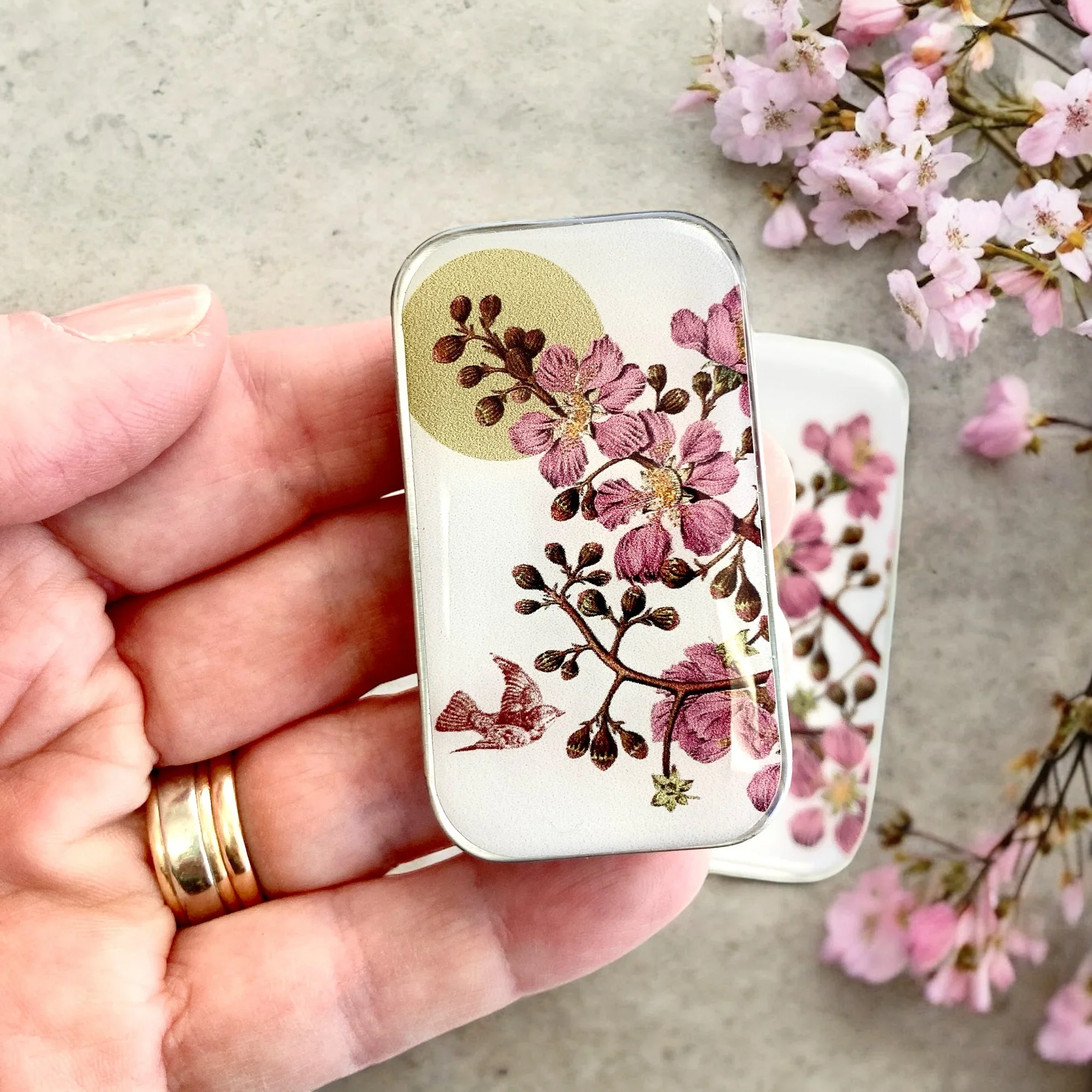 Cherry Blossom and Swallow Notions Tin by Firefly Notes featuring a delicate floral design and a graceful bird on a handcrafted resin-topped sliding tin.