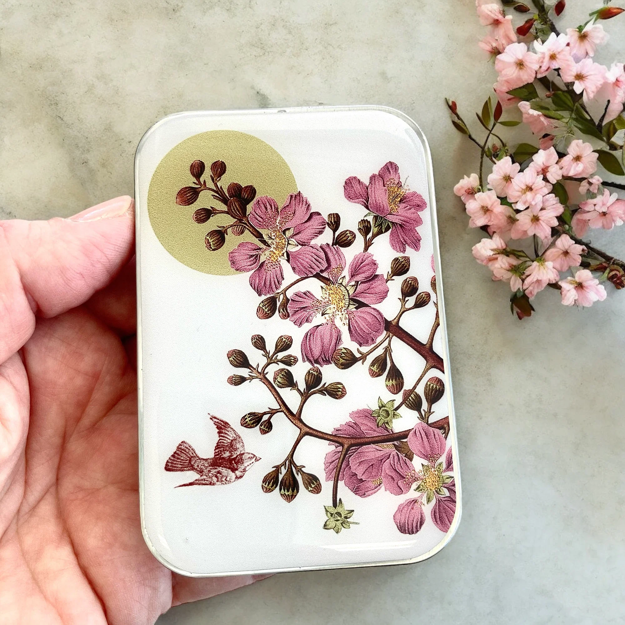 Cherry Blossom and Swallow Notions Tin by Firefly Notes featuring a delicate floral design and a graceful bird on a handcrafted resin-topped sliding tin.