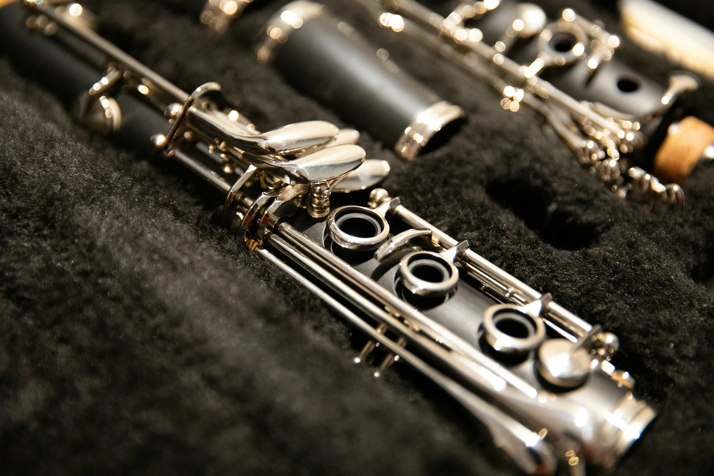 Close-up of a silver flute resting in a black case with foam padding.