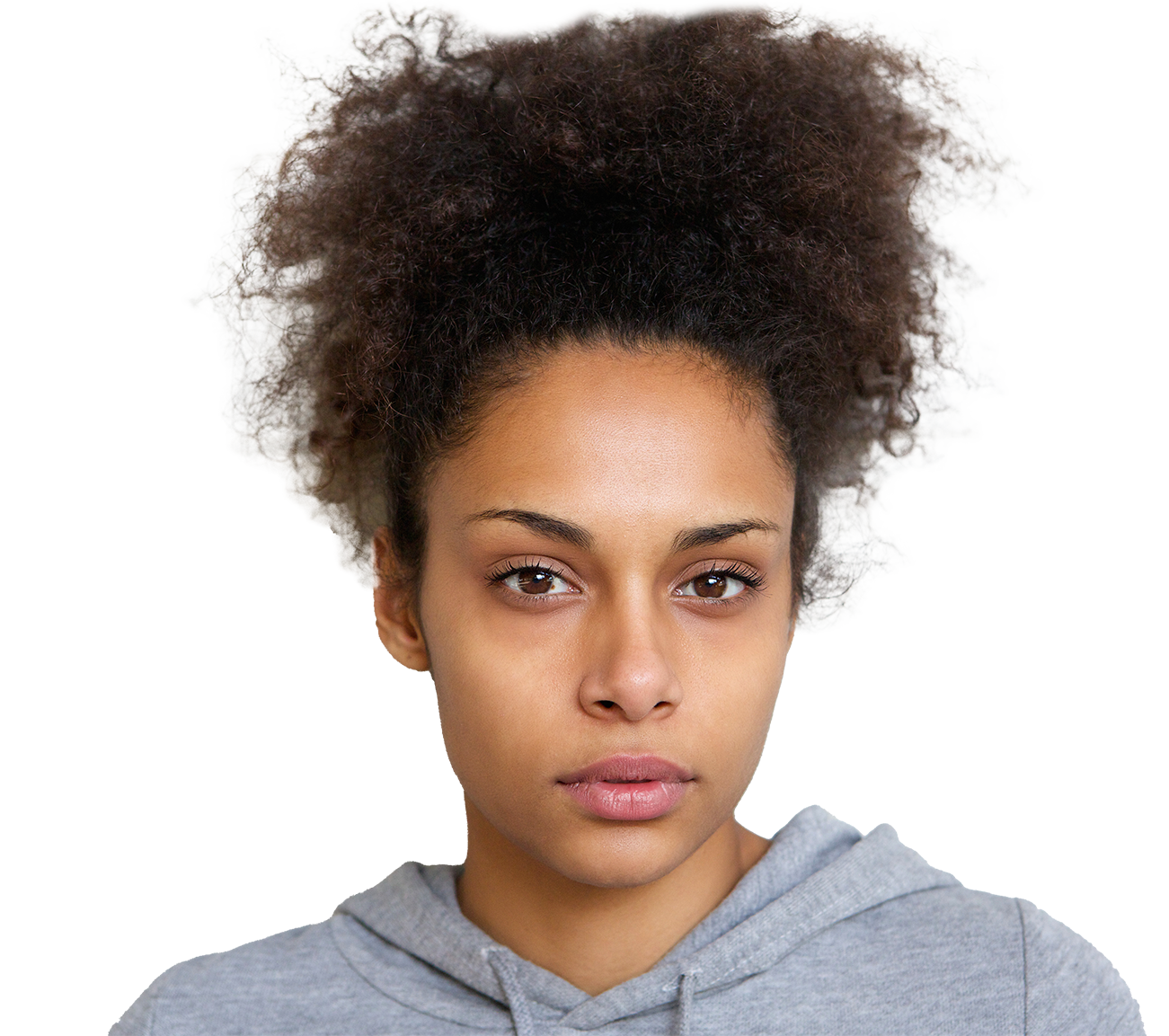 A young woman with natural curly hair tied up in a high puff, wearing a gray hoodie, looking directly at the camera.