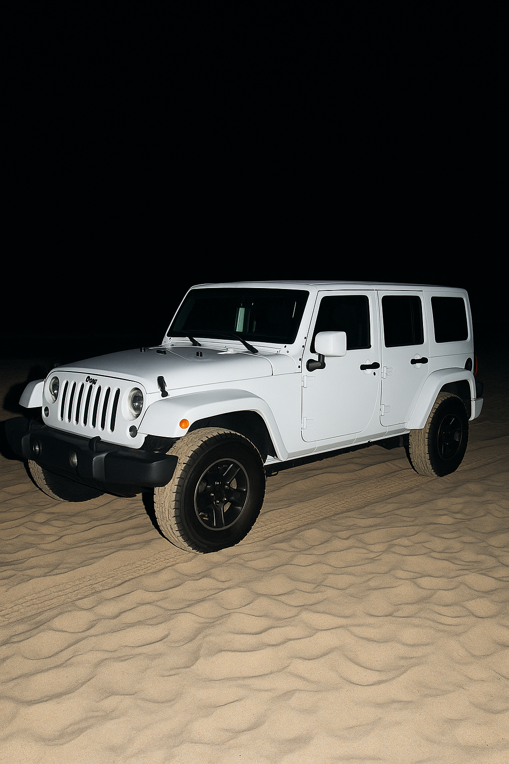 White Jeep SUV driving on sand at night with no background visible.