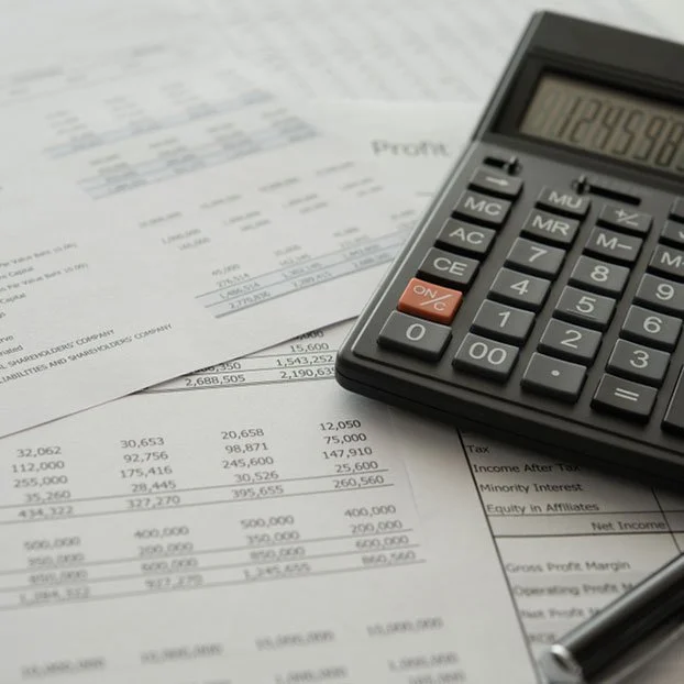 Calculator on financial documents with financial figures and text.
