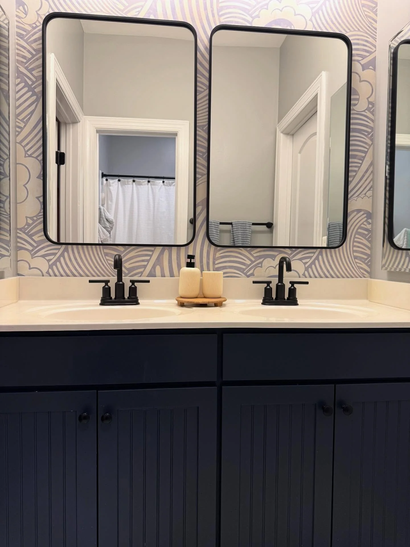 Fresh look, same bones 🌊 

This Jack &amp; Jill bathroom just got a mini facelift &mdash; fresh paint on the cabinets, updated fixtures, and some playful wallpaper to bring it all together. We kept the original tile, proving you don&rsquo;t need a f